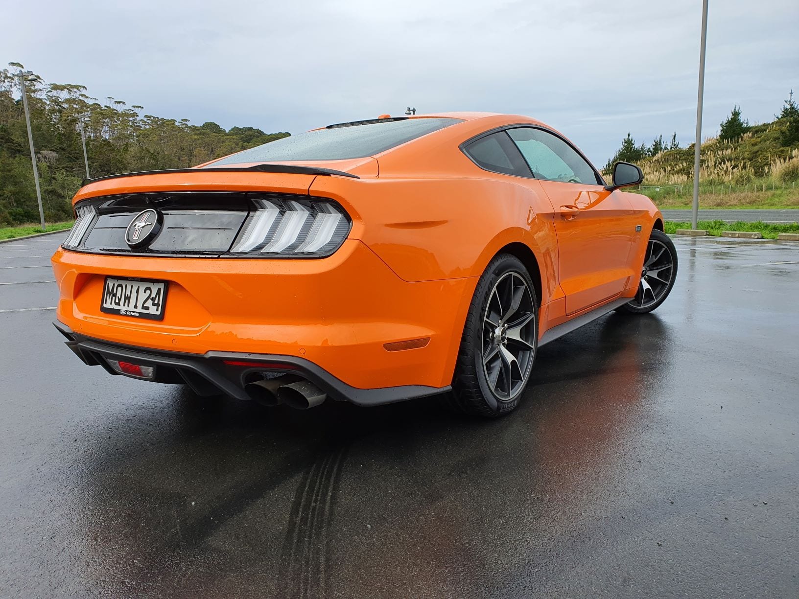 A rear three quarter shot of the Ford Mustang High Performance in orange.