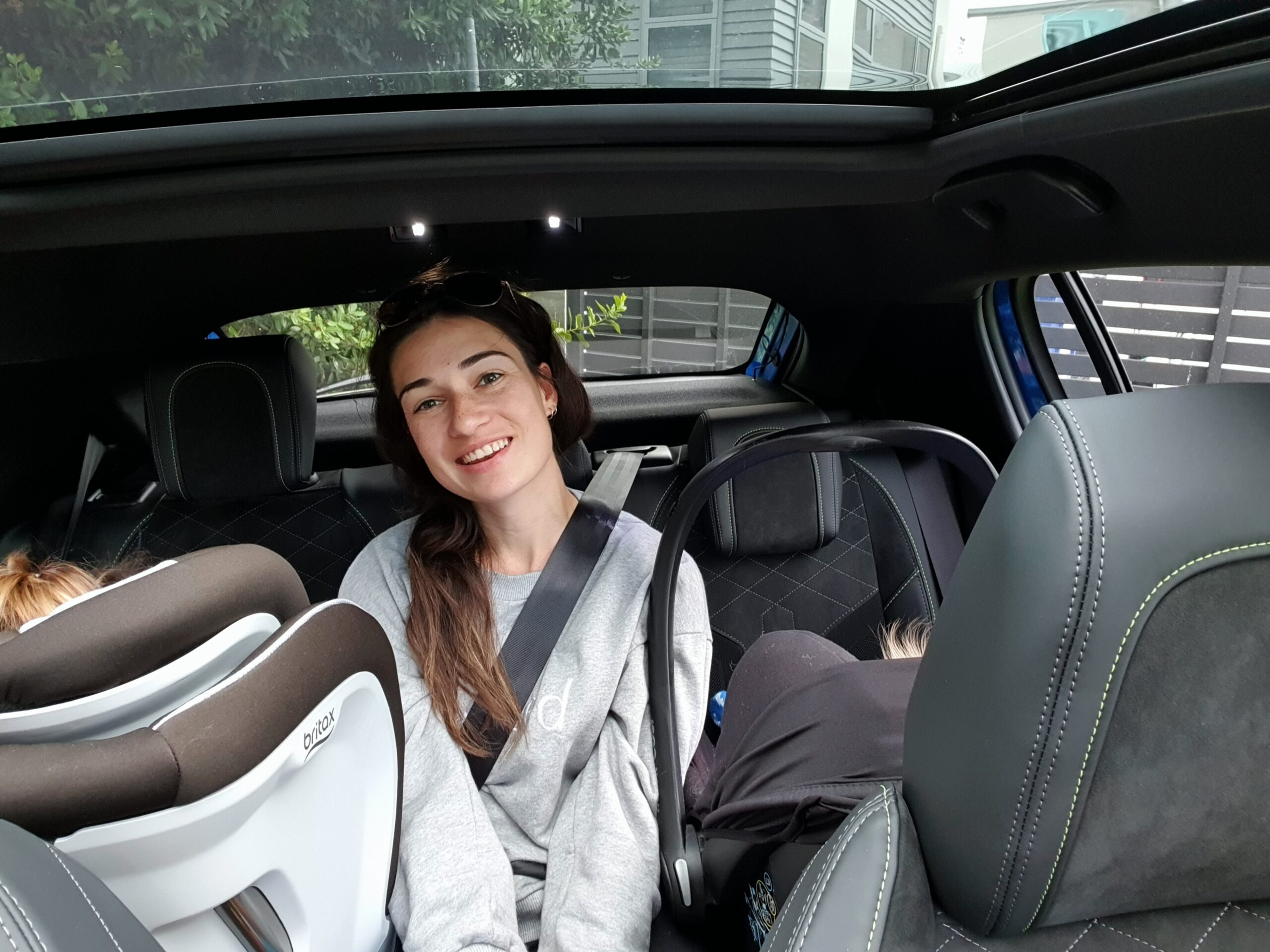 An adult sitting between two children in a 2022 Peugeot 208 GT