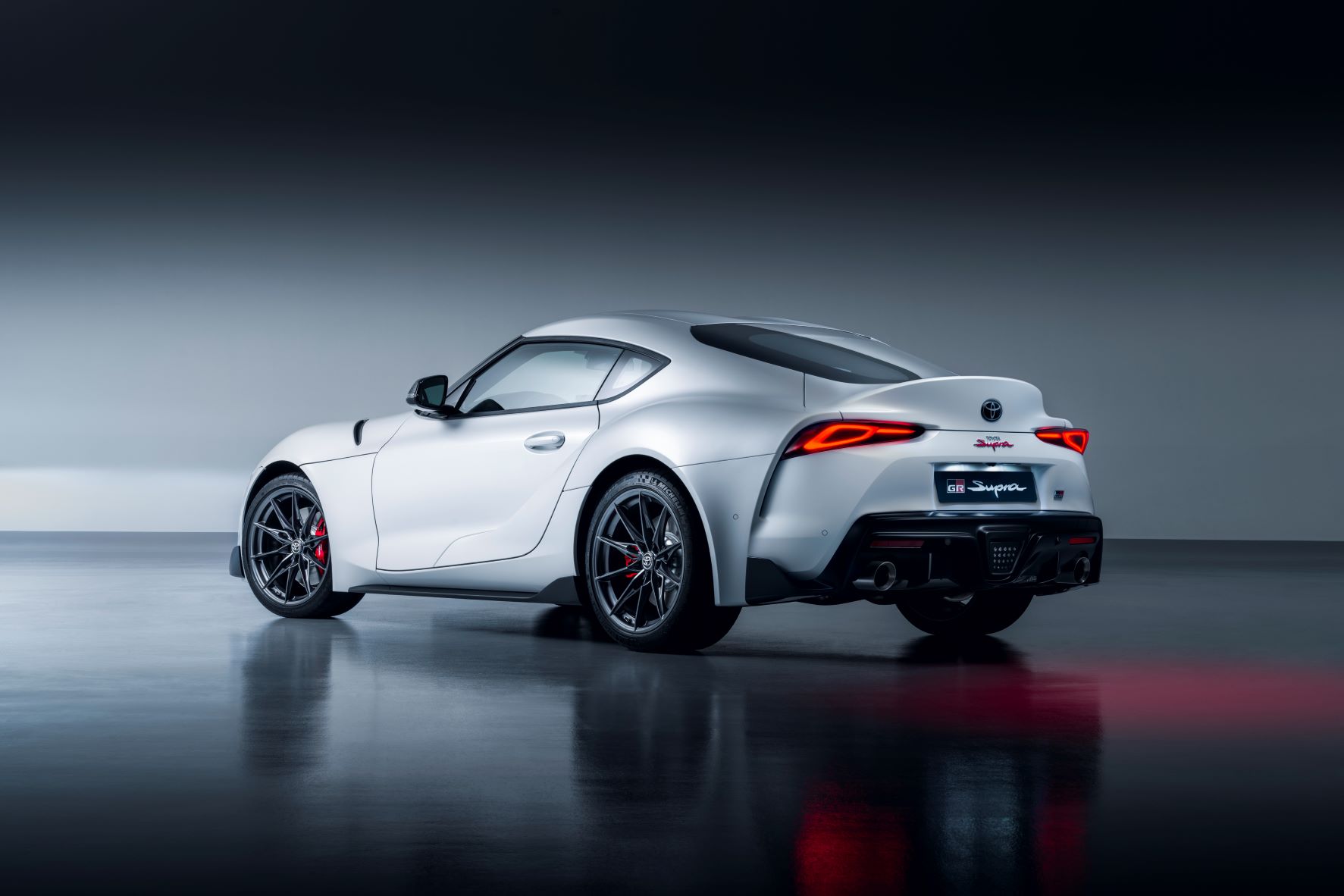 Rear three quarter view of new Toyota GR Supra in matte avalanche white metallic
