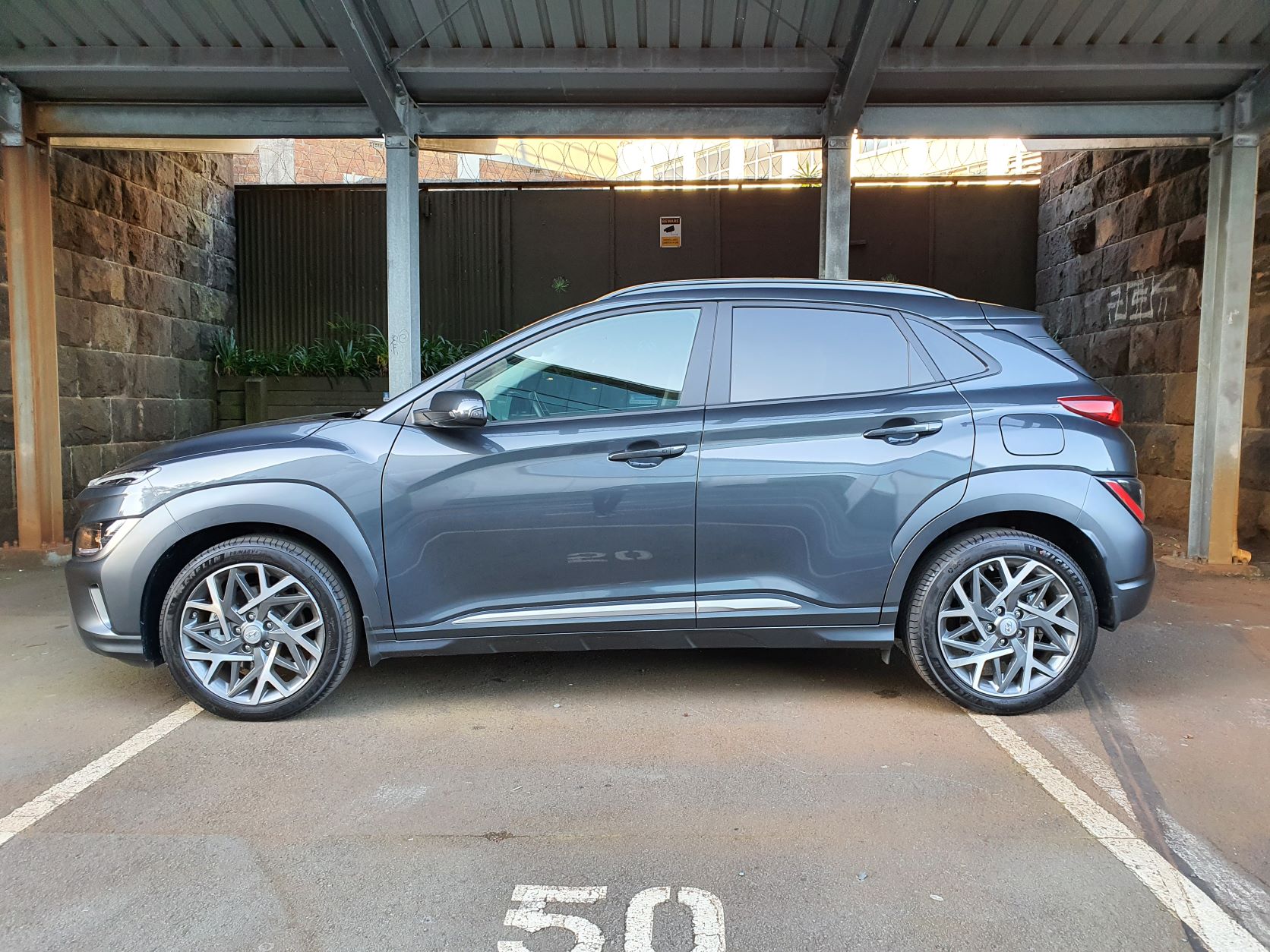 Side view of the 2022 Hyundai Kona Hybrid in bluish gray
