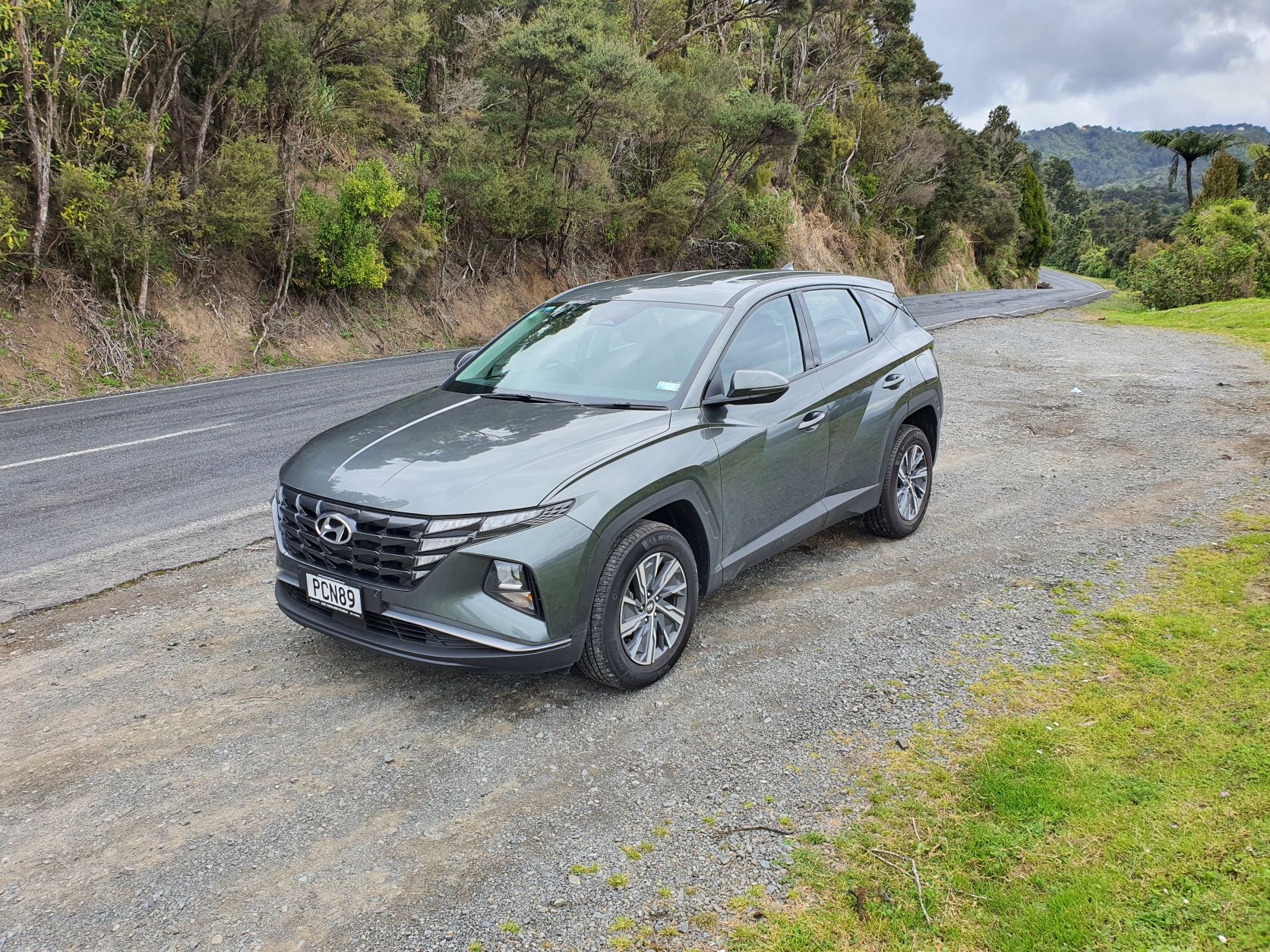 Three quarters zoomed out view of a 2022 Hyundai Tucson Hybrid in green
