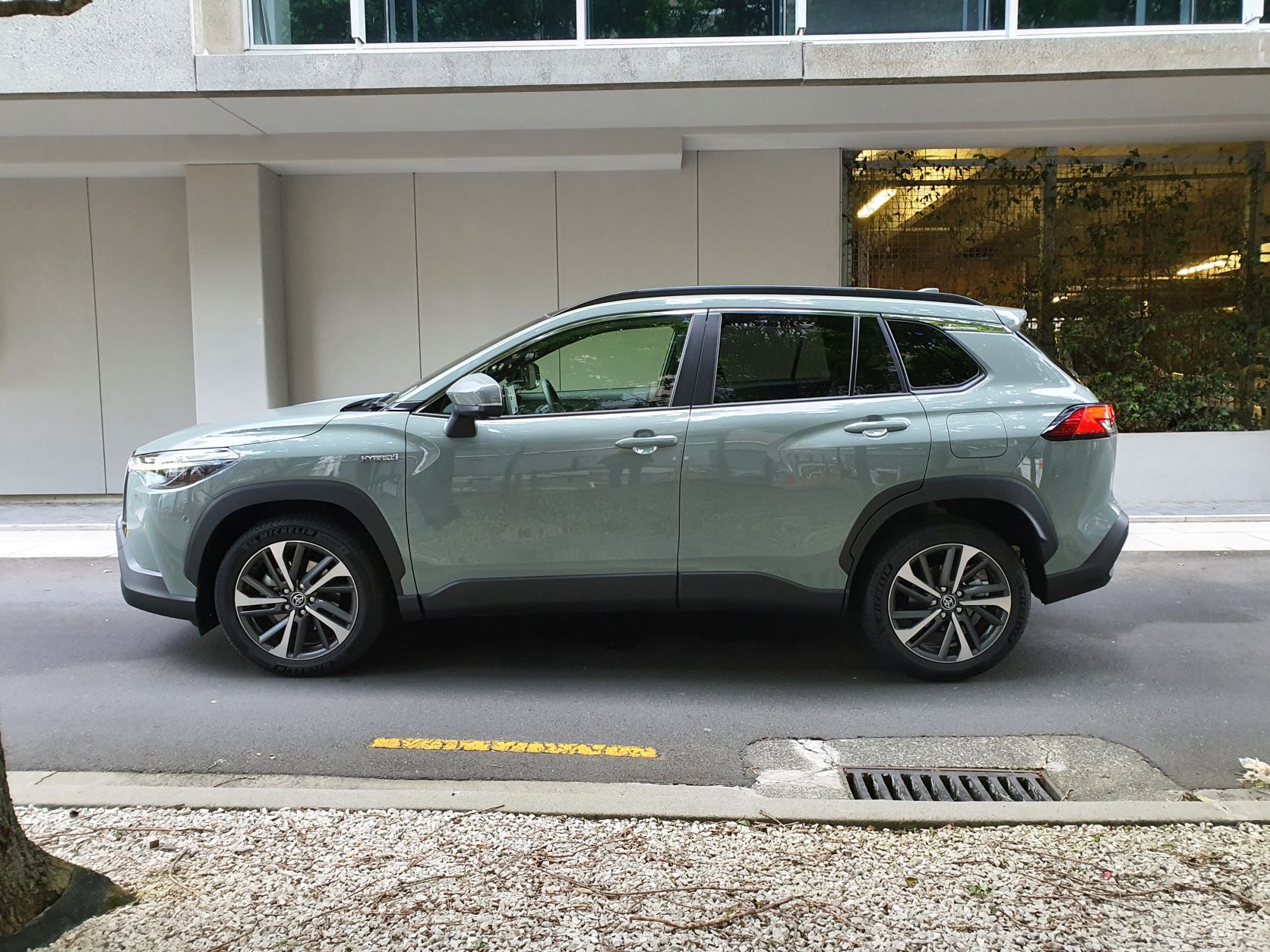 Side view of a 2022 Toyota Corolla Cross Limited Hybrid E-Four AWD in Safari Green