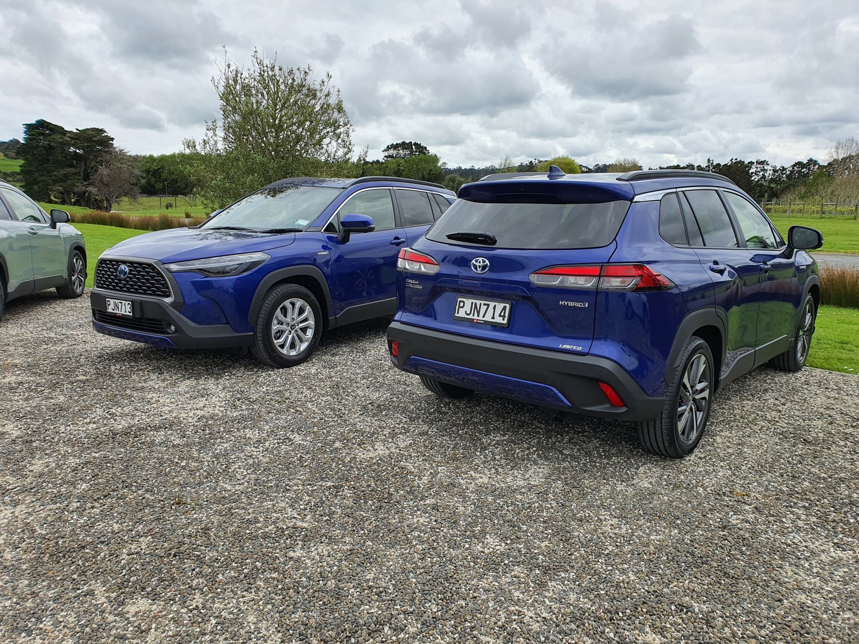 View of two blue Toyota Corolla Crosses, one facing forwards and one backwards