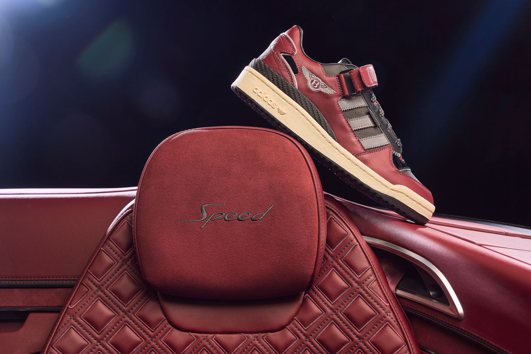 Bentley x The Surgeon Adidas Forum Low performance focus sneakers resting on the headrest of a Bentley Continental GT Speed convertible.
