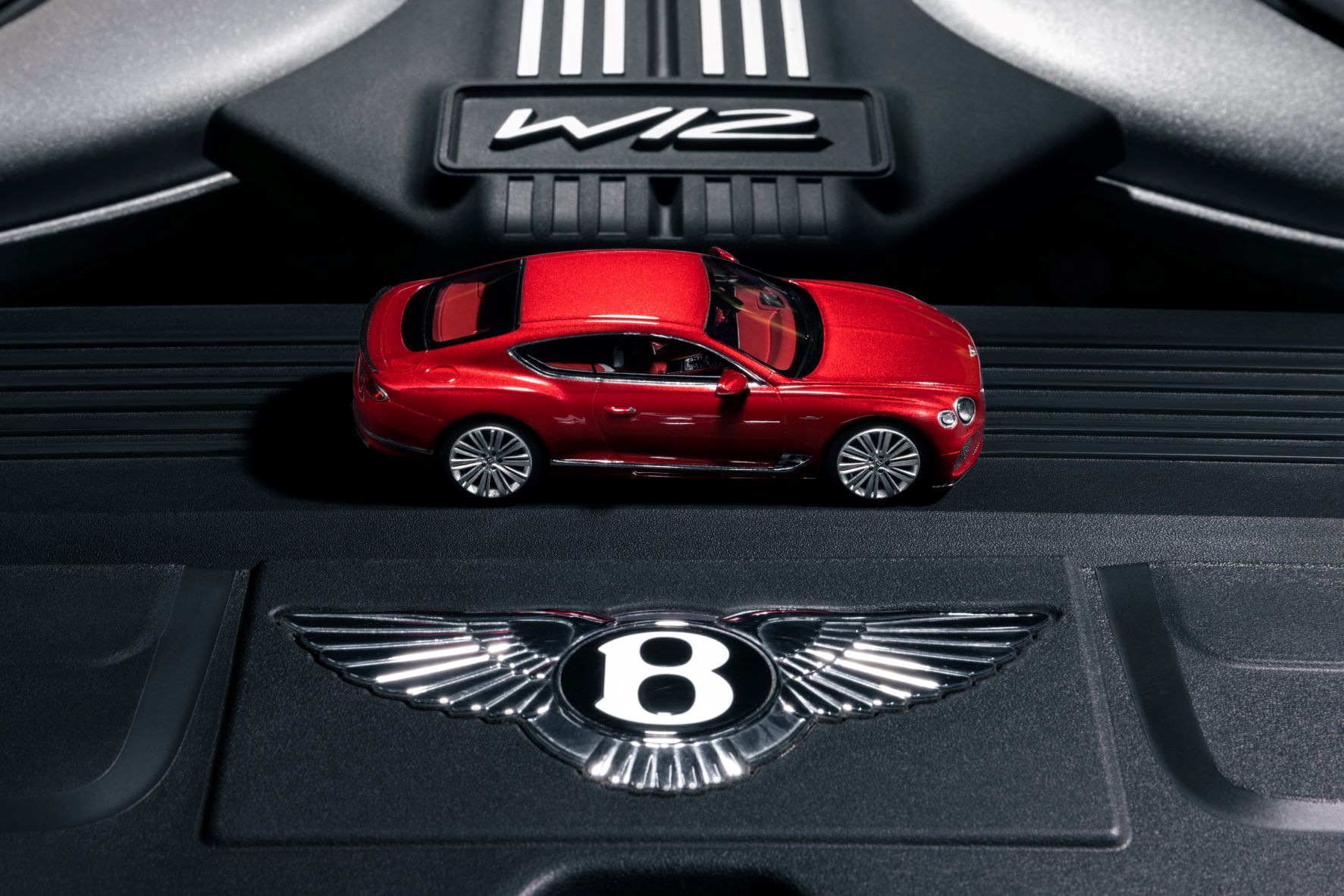 A Candy Red Bentley Continental GT Speed model sits on the engine bay of a W12 powered Bentley Continental GT Speed.
