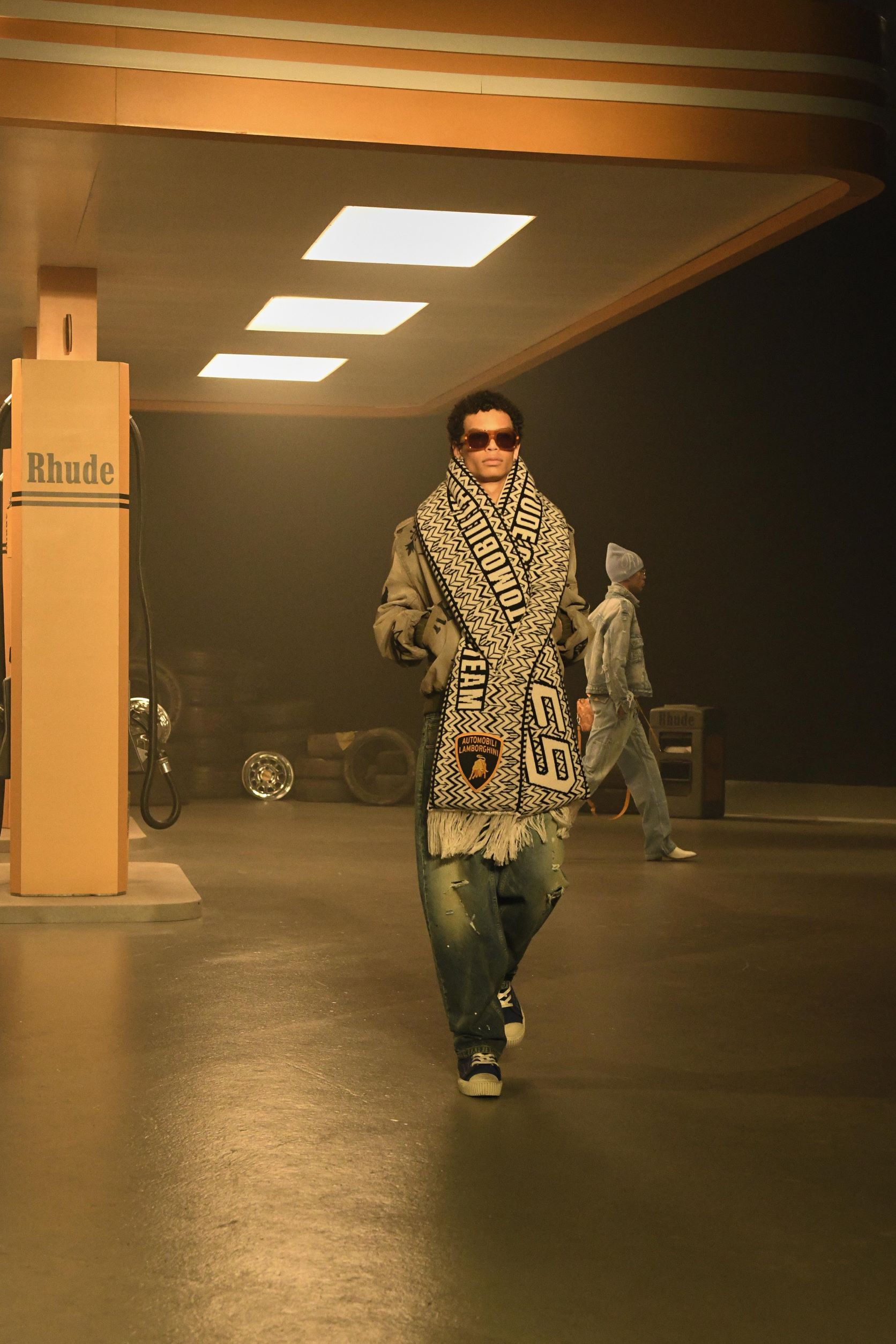 A model wearing a black and white Rhude x Lamborghini scarf at the recent collection display.