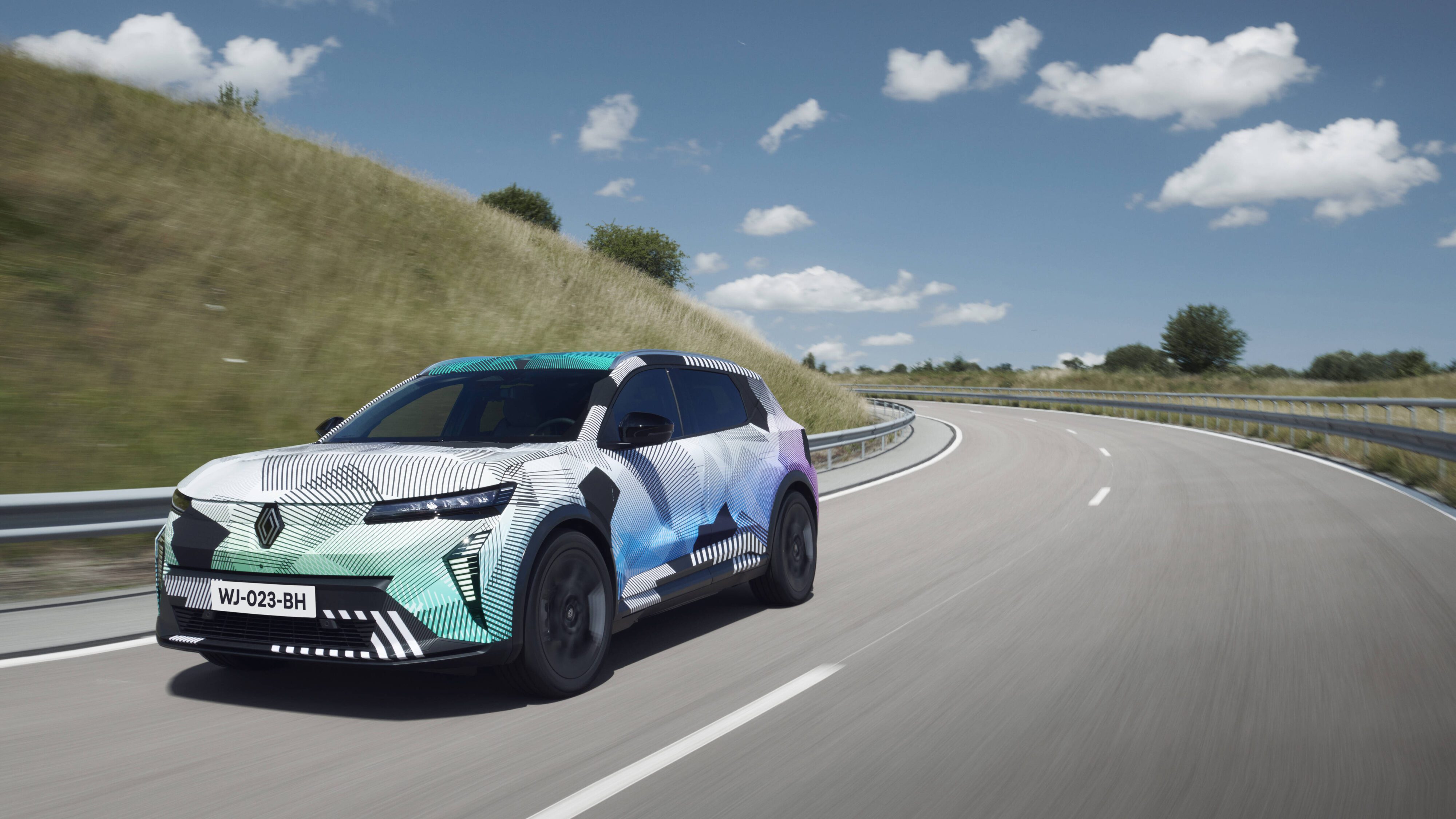 Motion shot of a new Renault Scenic e-tech under camouflage