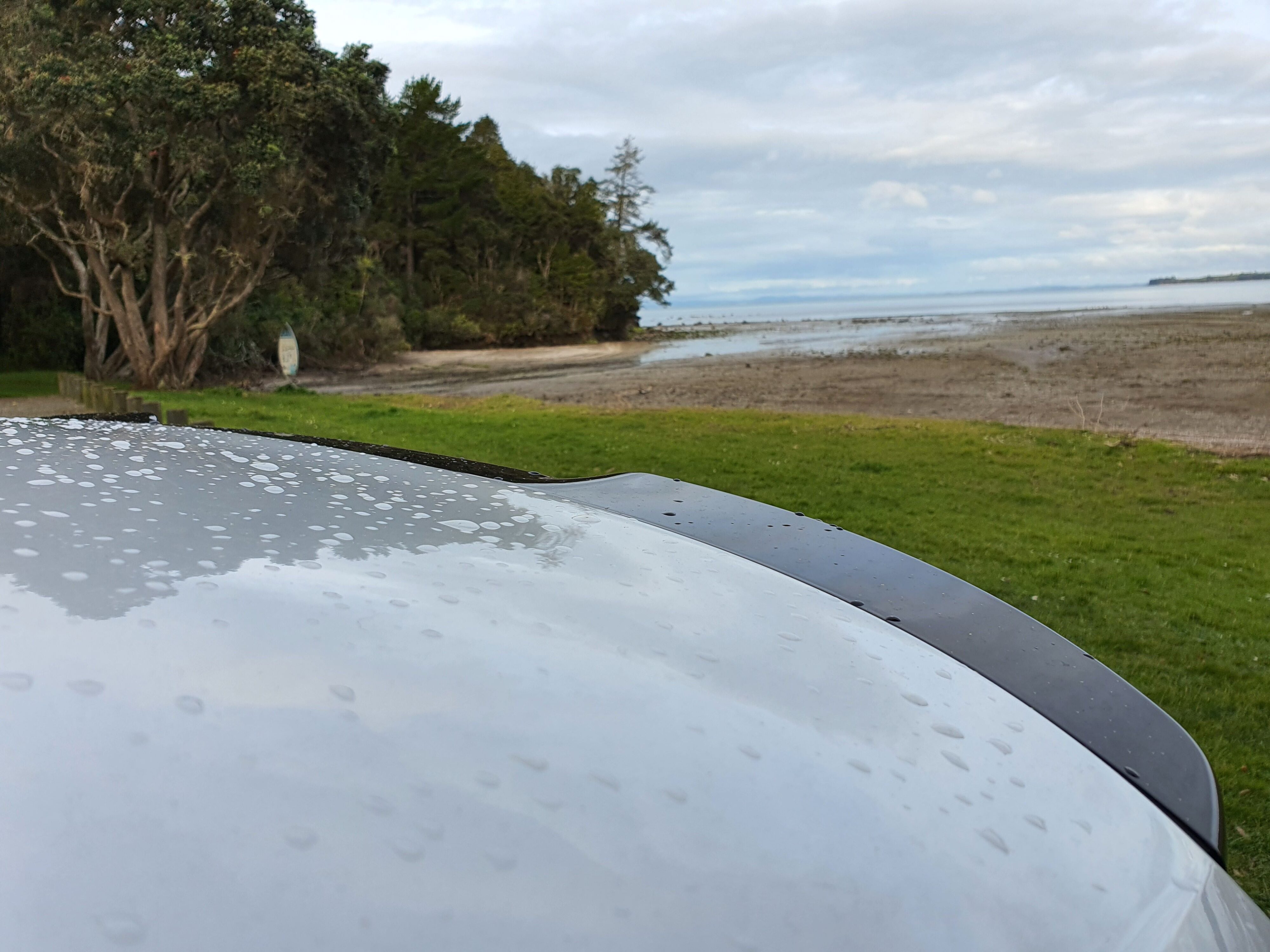 Black lip spoiler on the rear of the Cupra Leon V in Nevada White with a seaside background