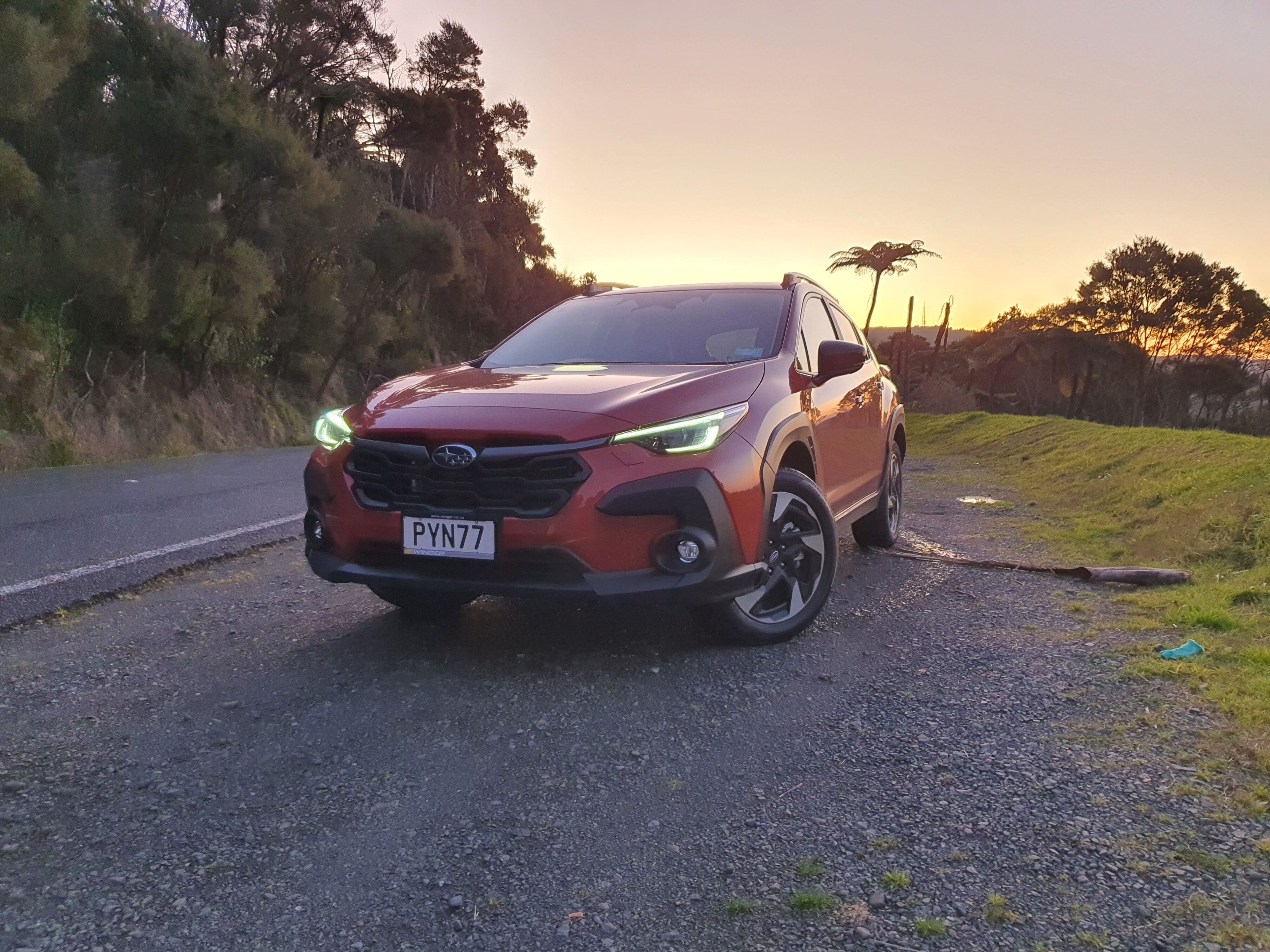 Front three quarters view of a 2023 Subaru Crosstrek Petrol Premium in Sun Blaze Pearl at sunset