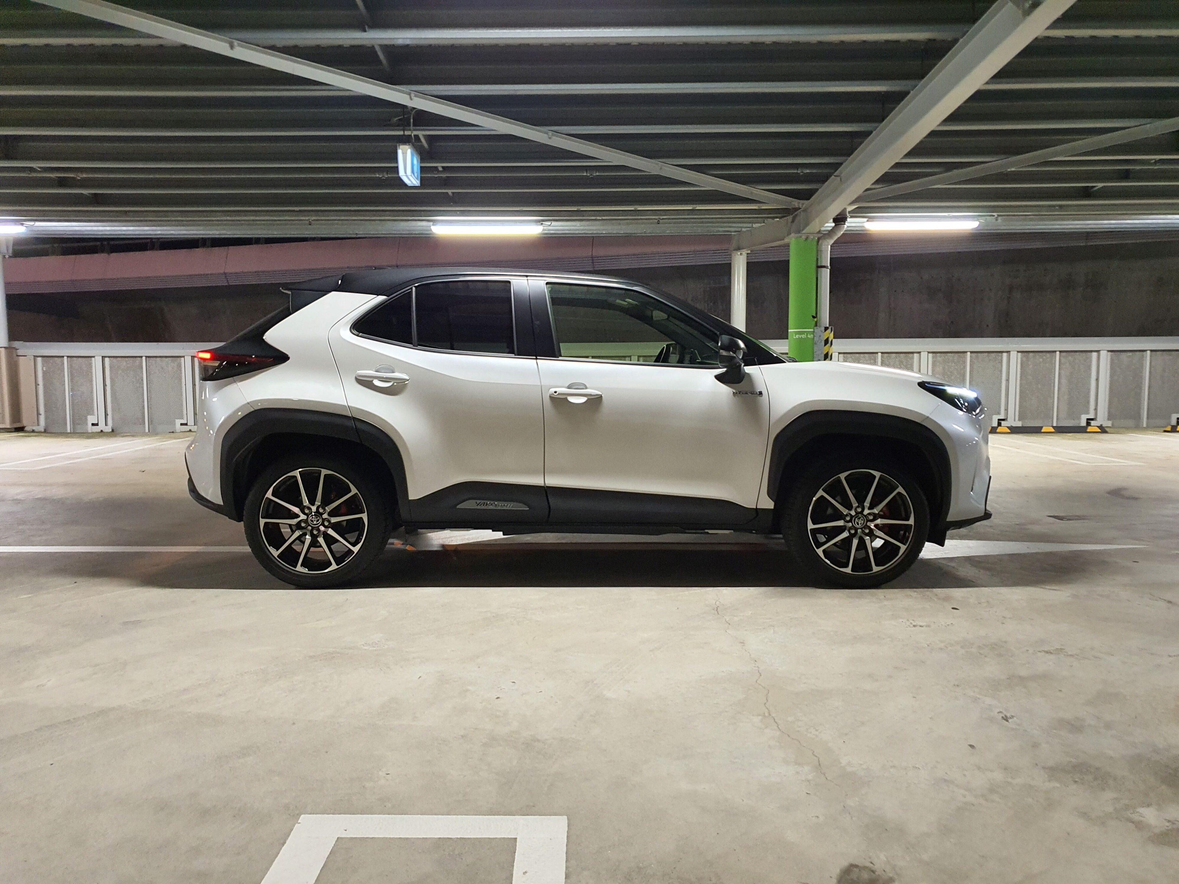 Side on view of a 2023 Toyota Yaris Cross GR Sport in a white and black colour scheme.