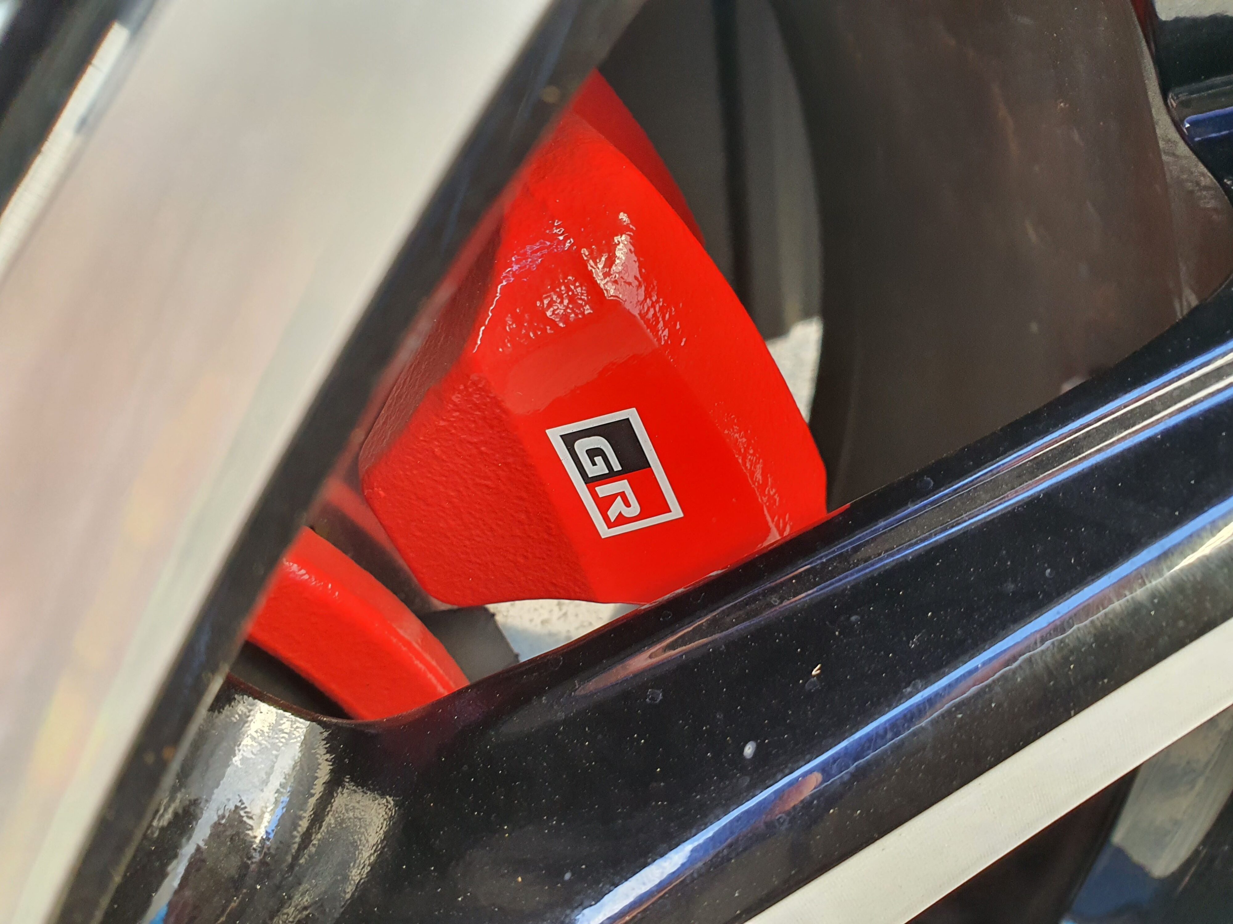 A photo of the painted red Toyota GR brake calipers on a 2023 Toyota Yaris Cross GR Sport.