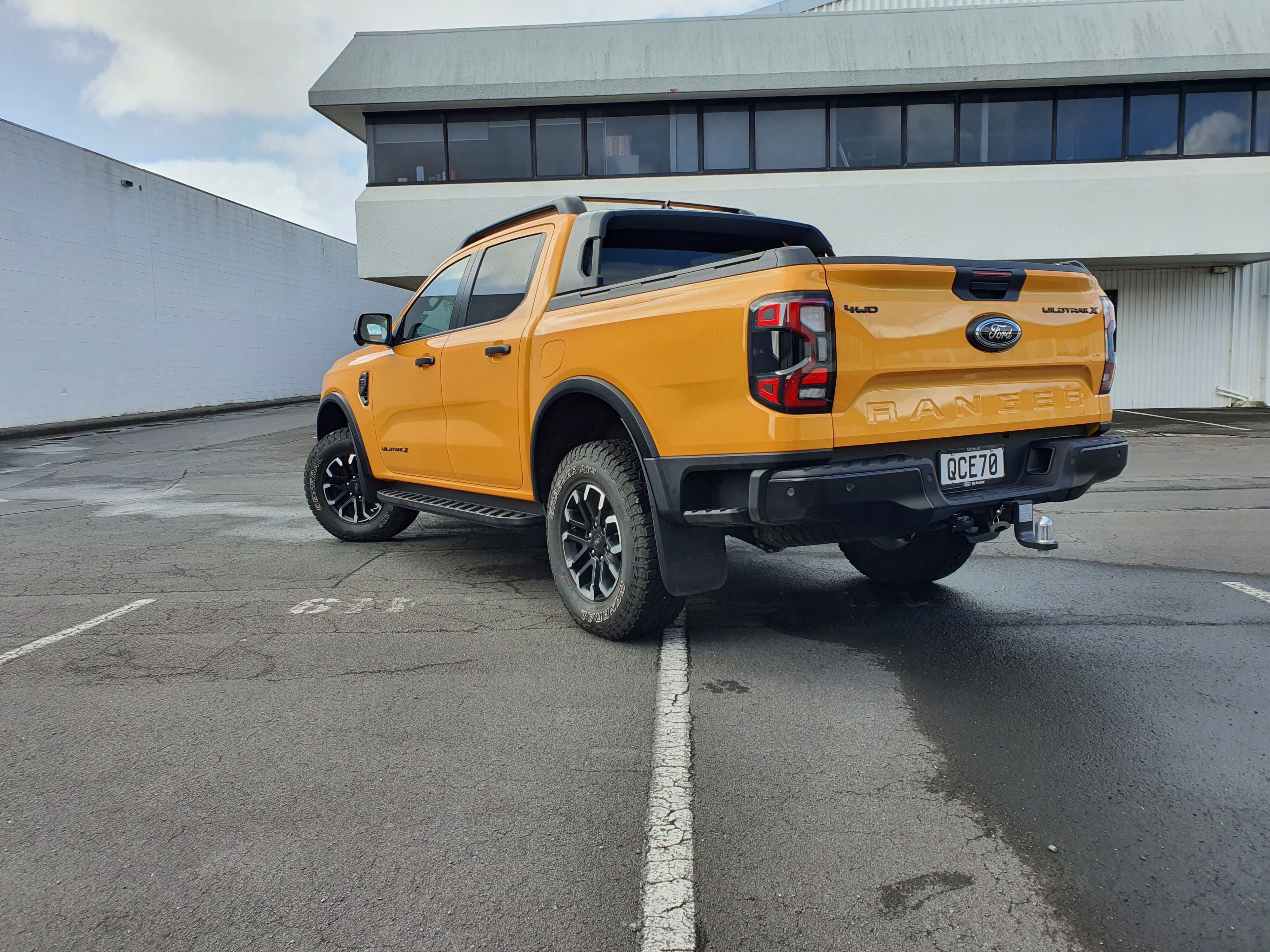 Rear three quarters view of a 2023 Ford Ranger Wildtrak X in Cyber Orange.