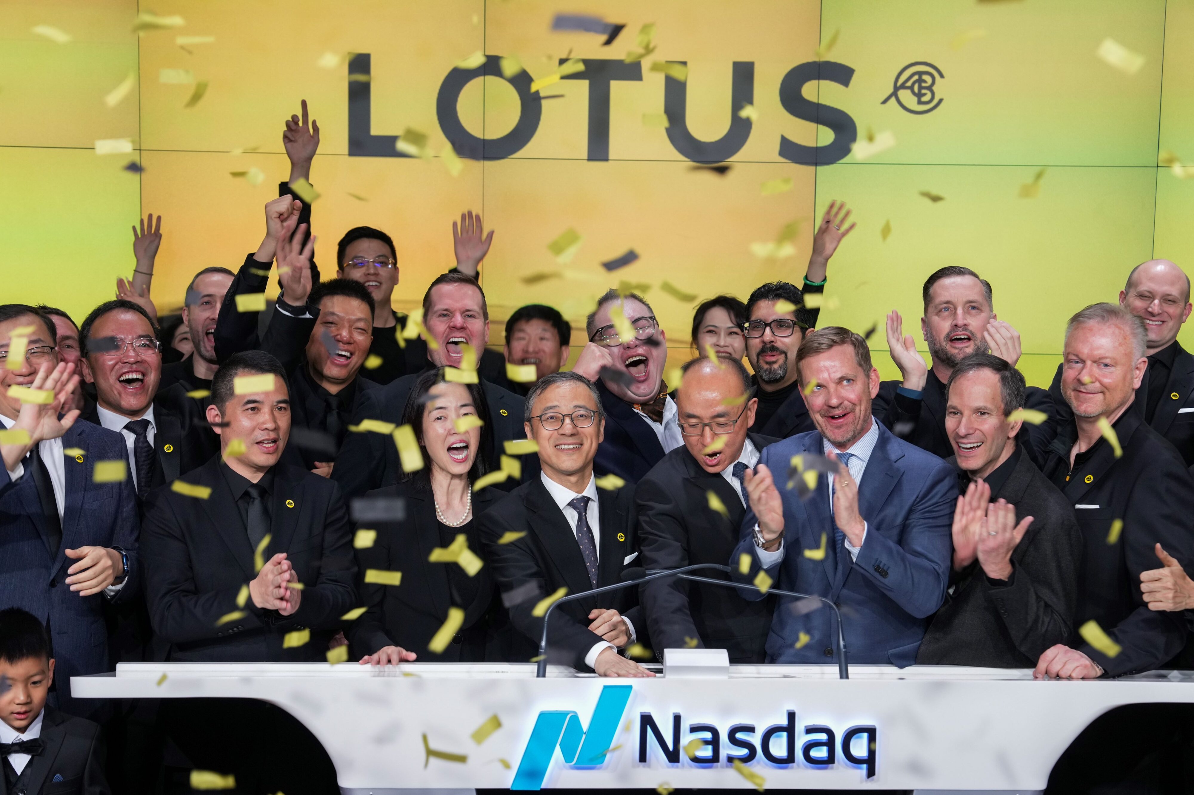 An image of Lotus going public on NASDAQ with senior staff members celebrating.
