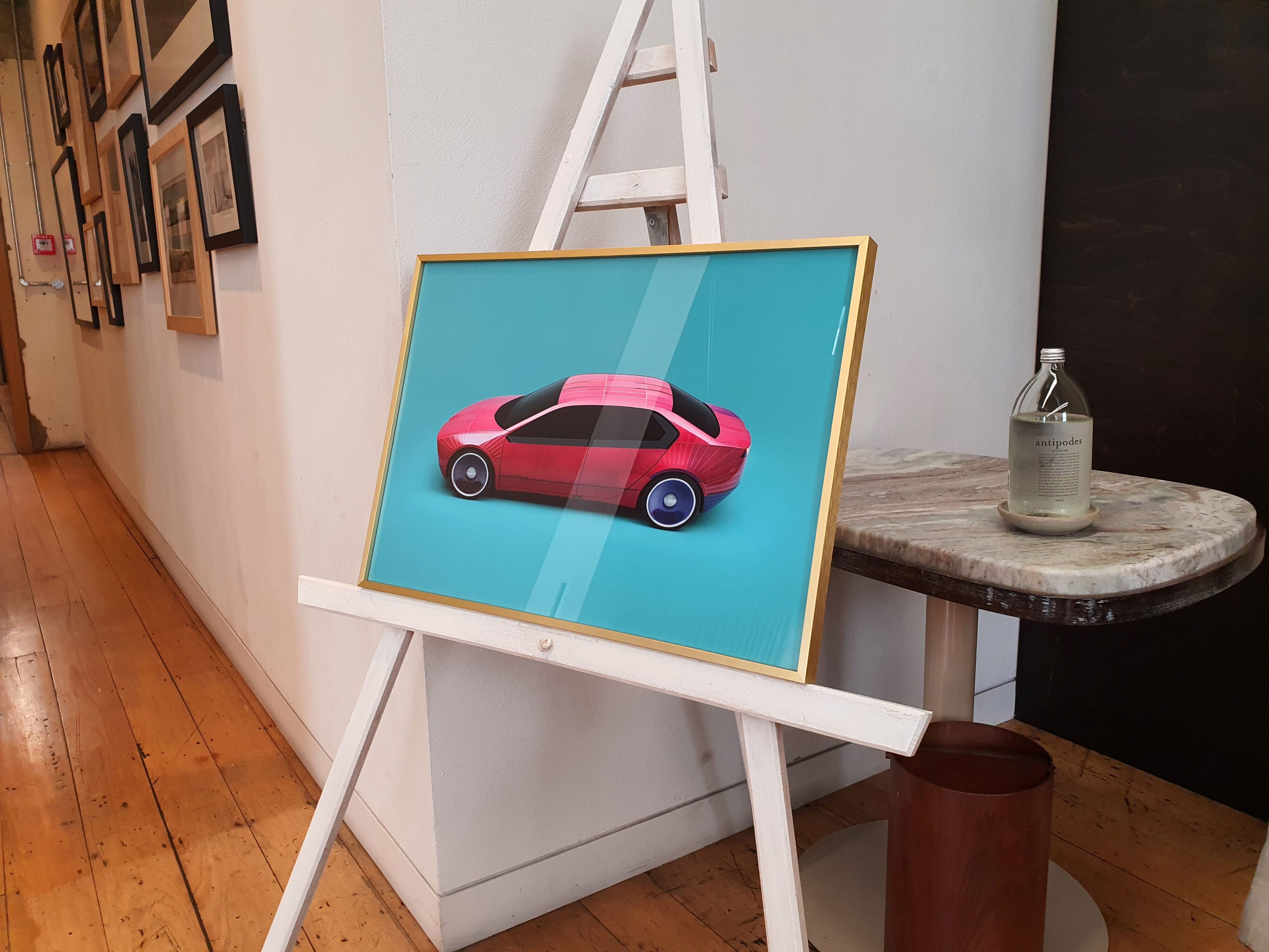 A framed print of the BMW Vision Dee concept on an easel in The Hotel Britomart, Auckland.
