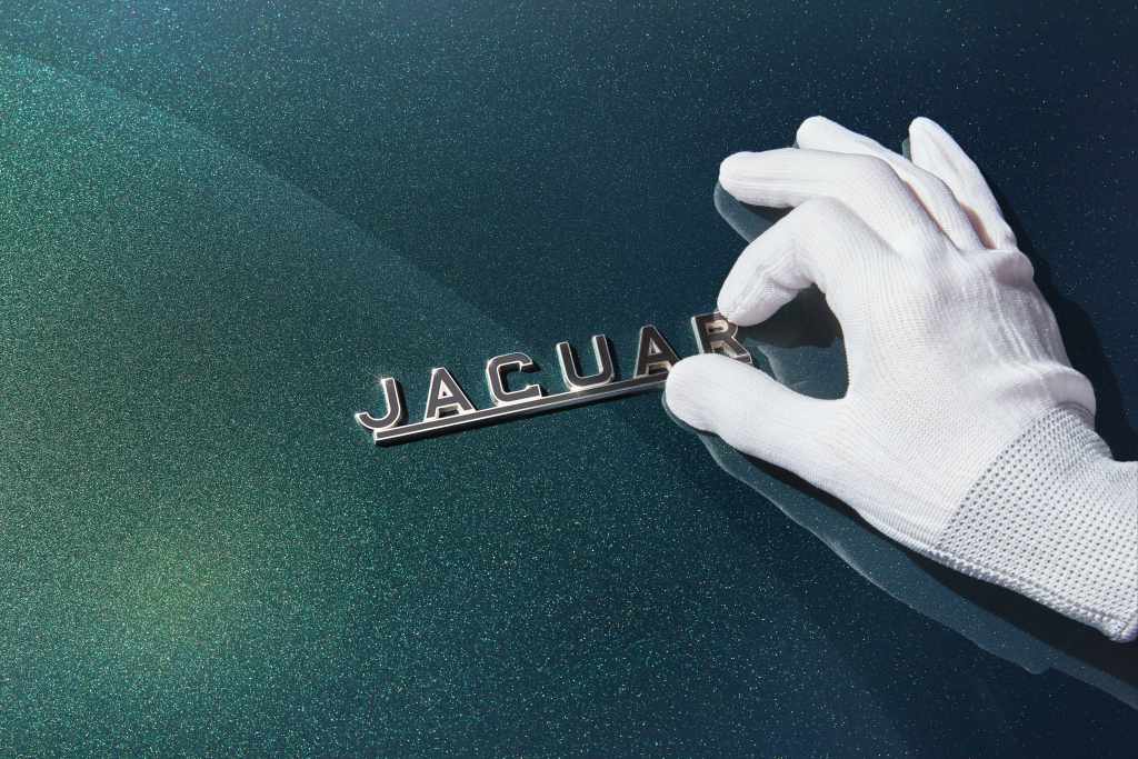 18 carat gold Jaguar emblem being applied to the 2024 Jaguar E-type drophead coupe in Signet Green.