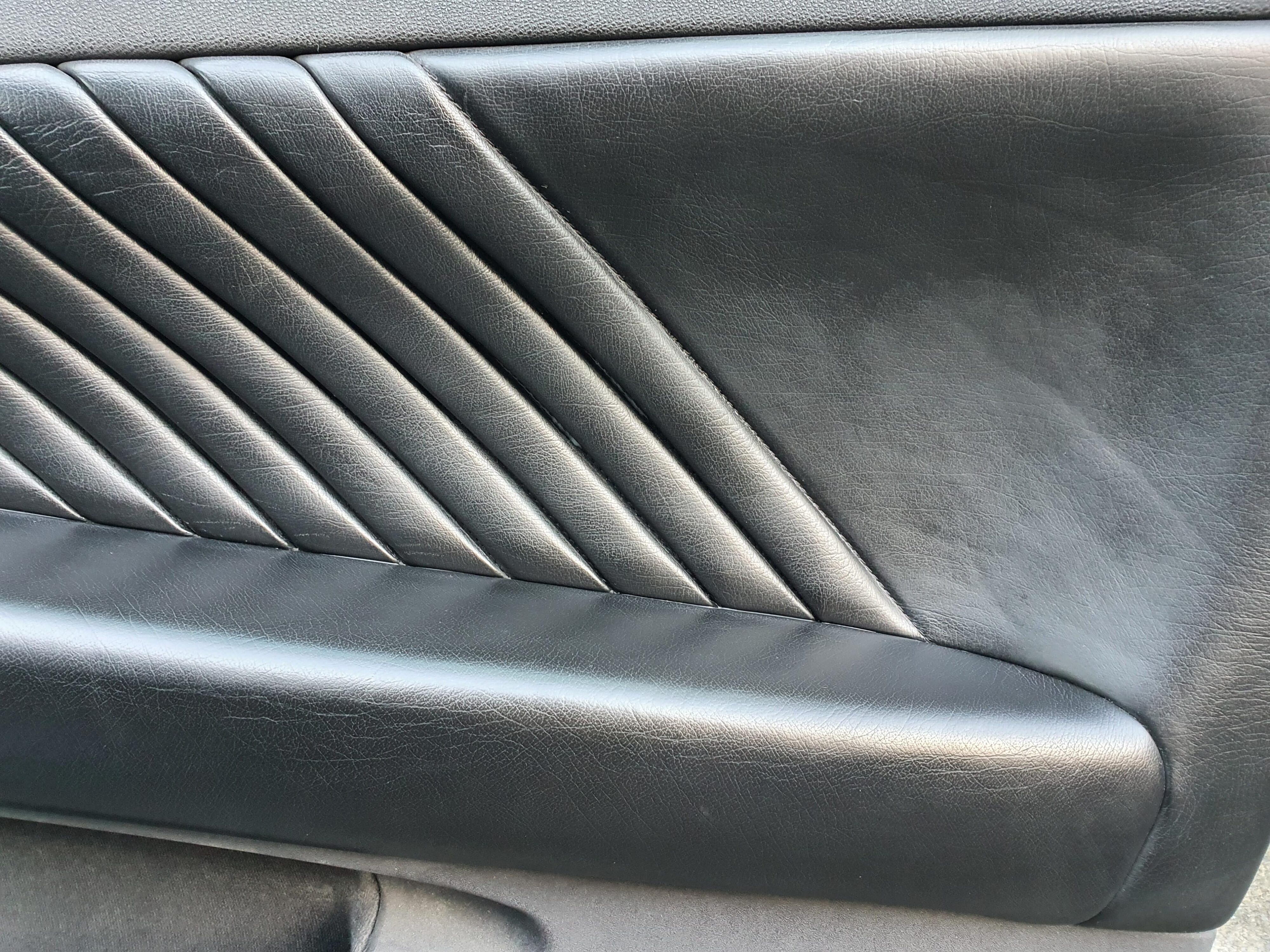 A photo of the right interior door card on a 2004 Alfa Romeo 147 GTA after using Armor All's Leather new Protectant.