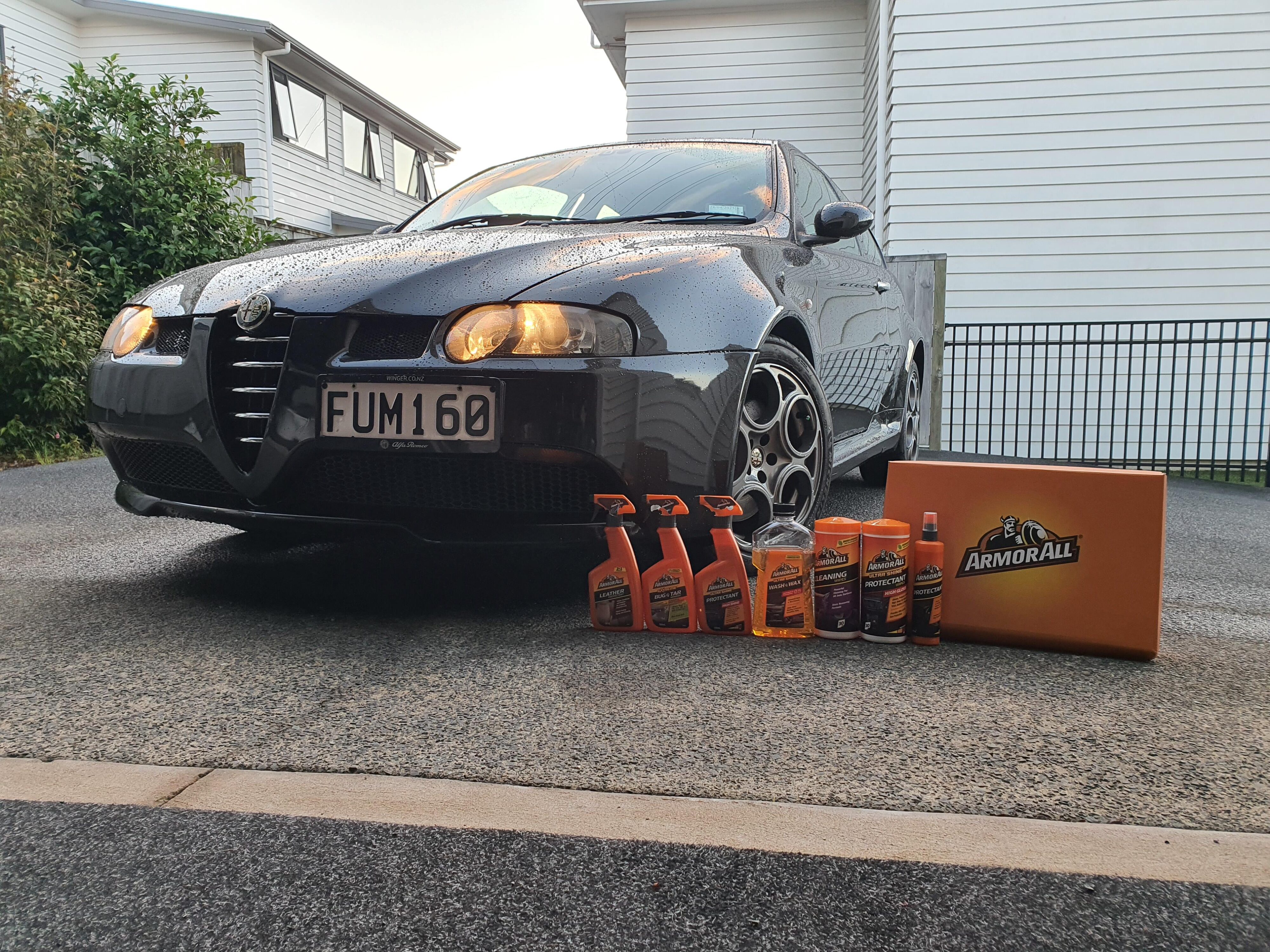 Front three quarters view of a black Alfa Romeo 147 GTA pictured with Armor All's new range of car care products.