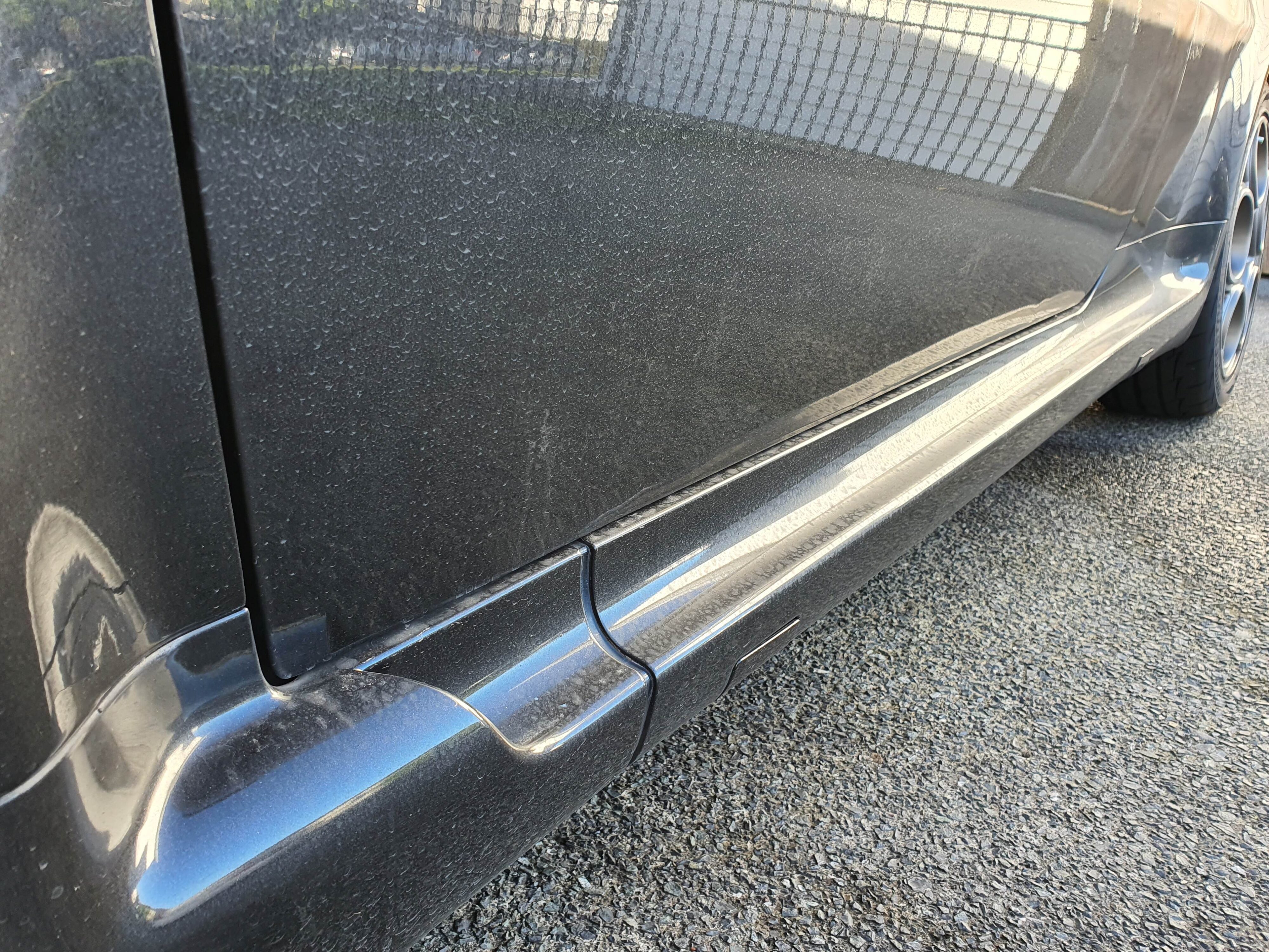 A left side door panel on a 2004 Alfa Romeo 147 GTA showing water spots, dust and other road dirt.