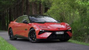 Front three quarters view of a 2024 Lotus Emeya S in Fireglow Orange.