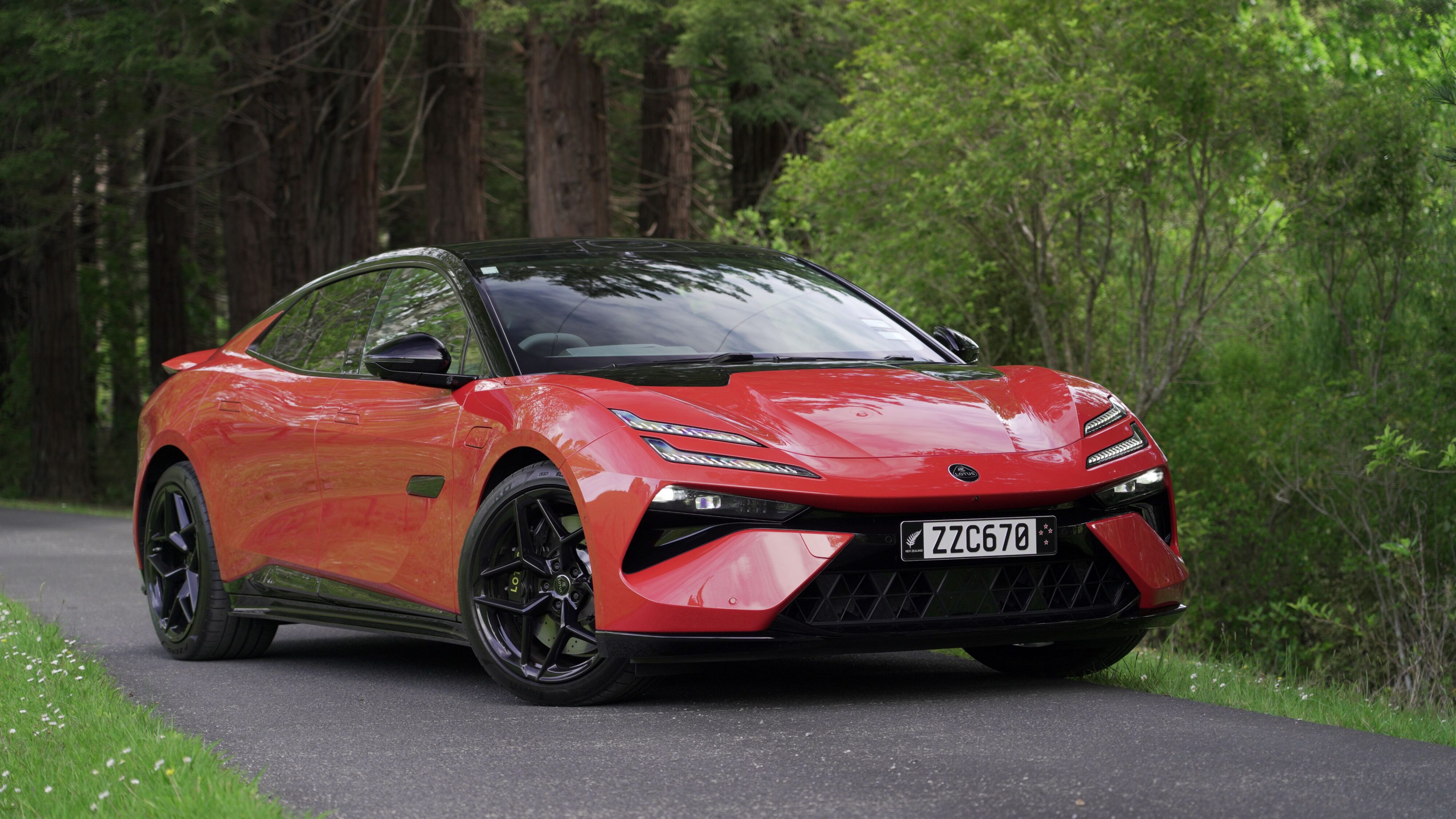 Front three quarters view of a 2024 Lotus Emeya S in Fireglow Orange.