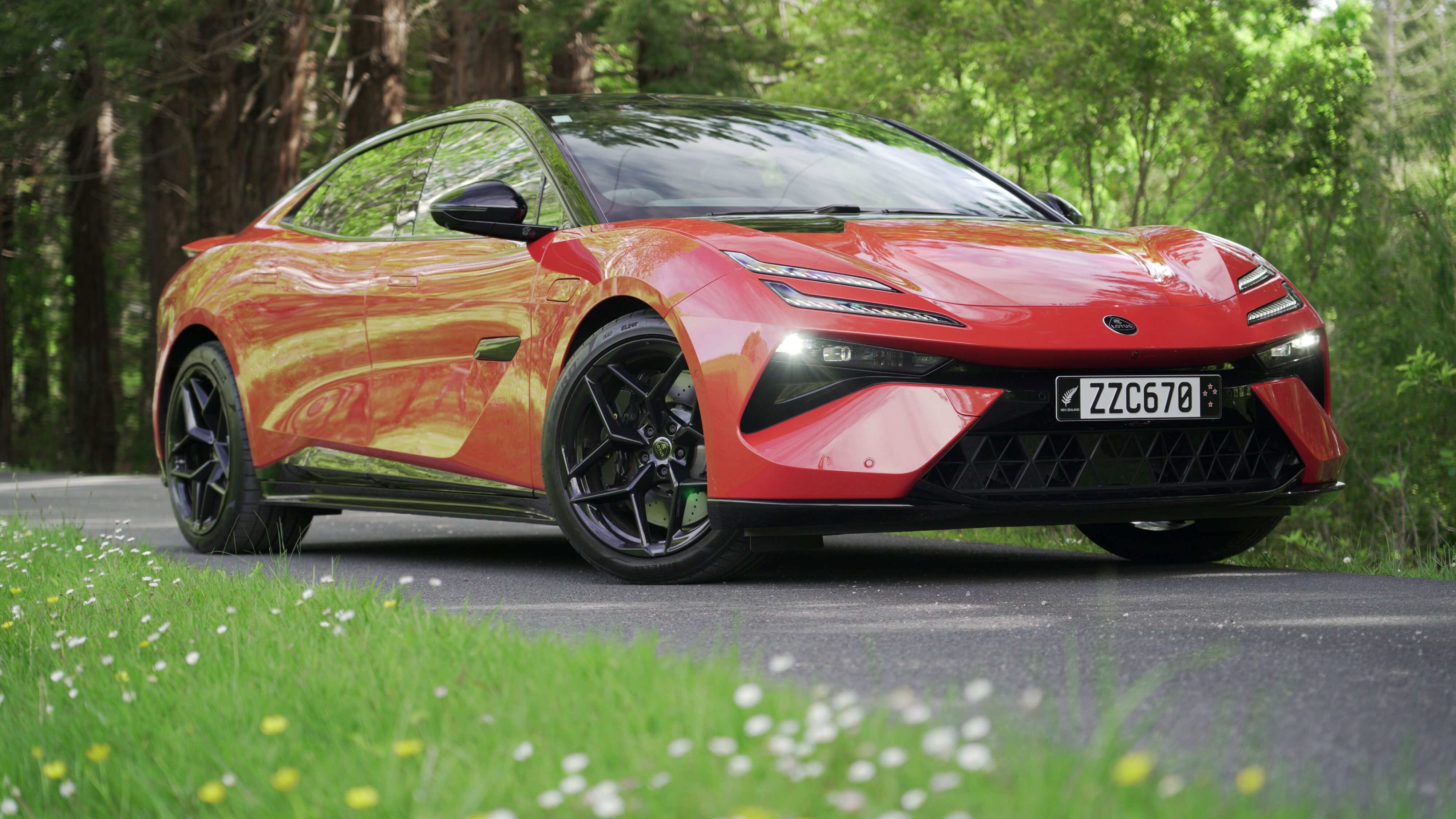 Front three quarters view of a 2024 Lotus Emeya S in Fireglow Orange.