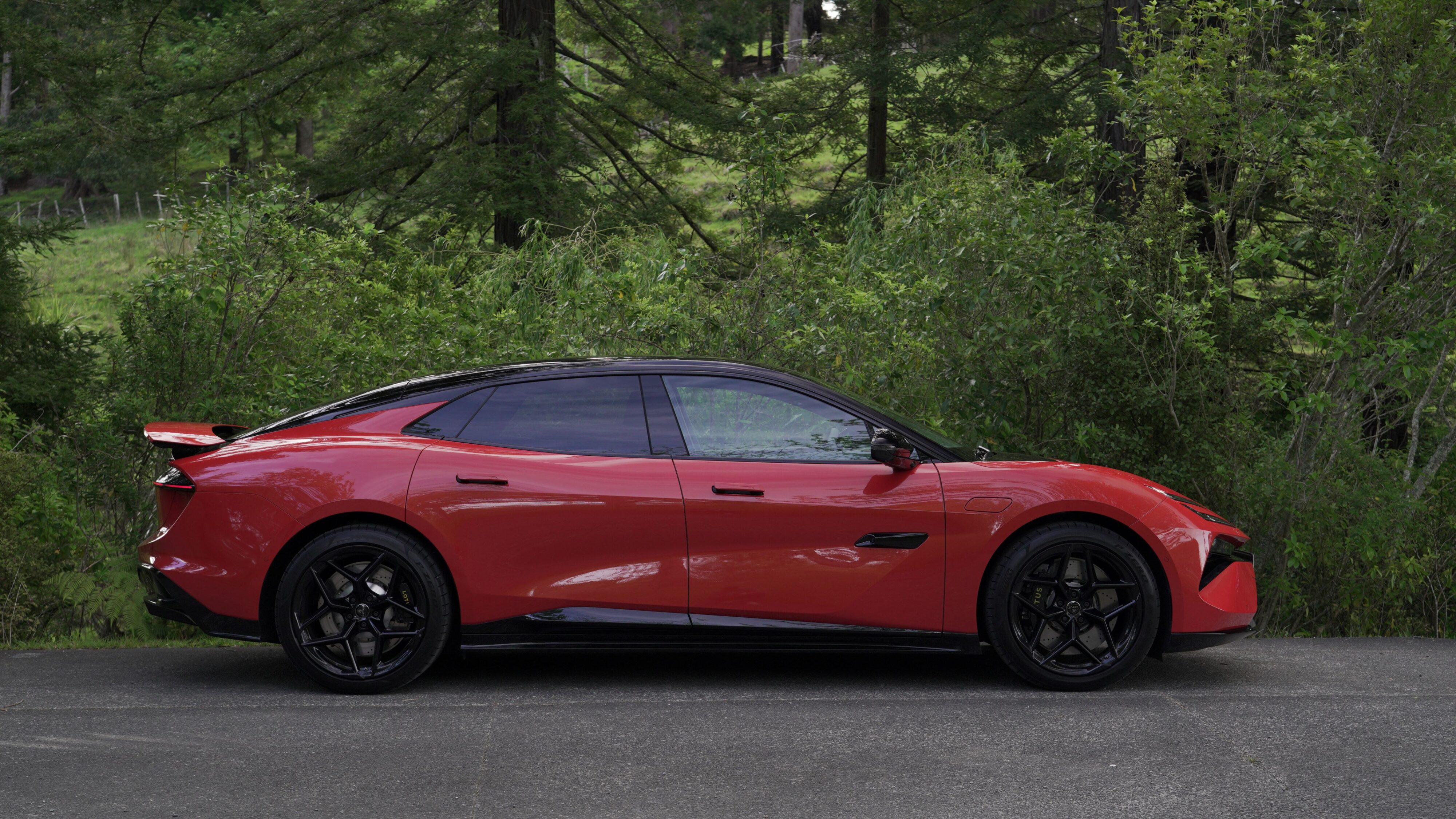 Side view of a 2024 Lotus Emeya S in Fireglow Orange.