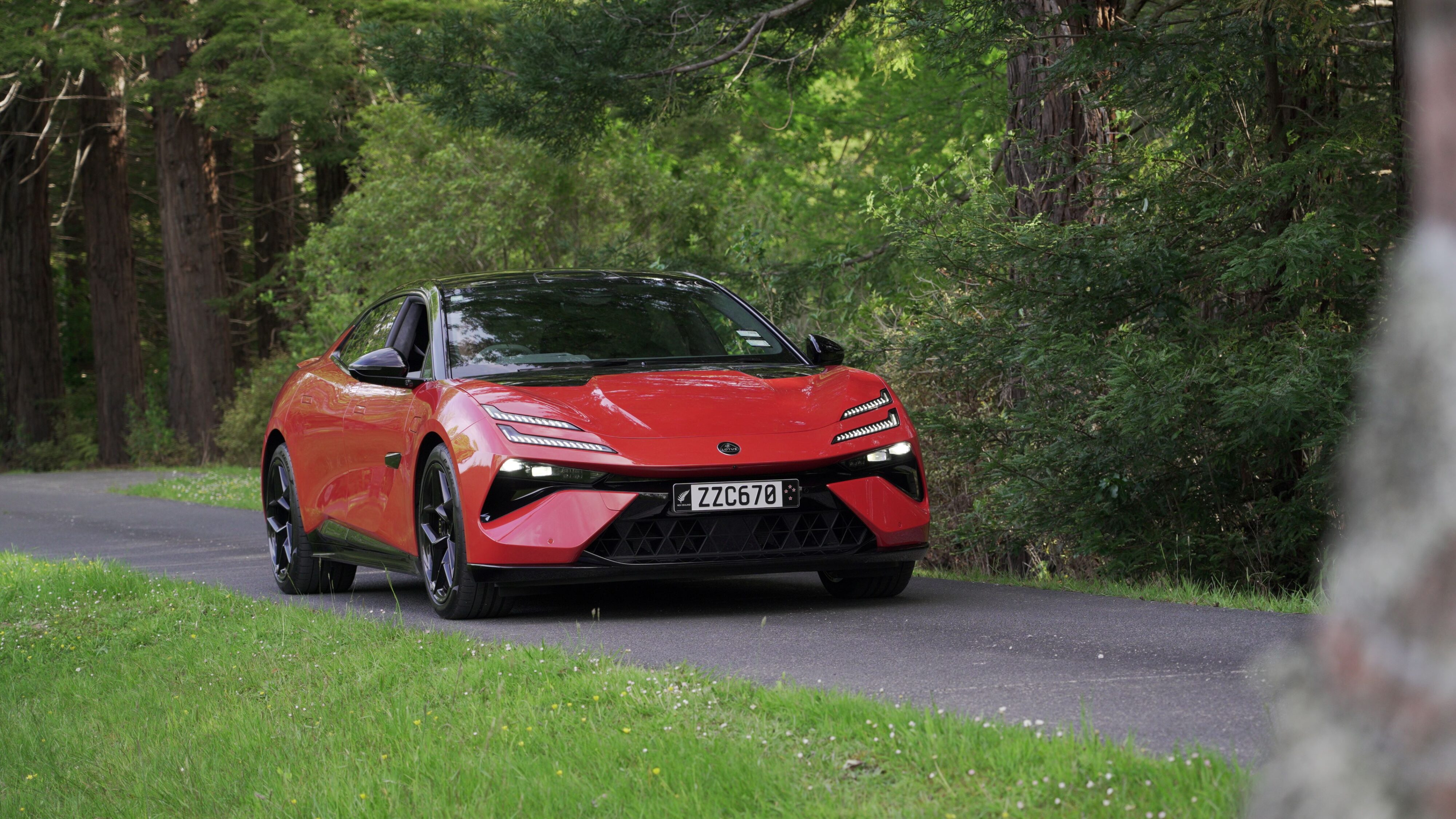 Front three quarters view of a 2024 Lotus Emeya S in Fireglow Orange.