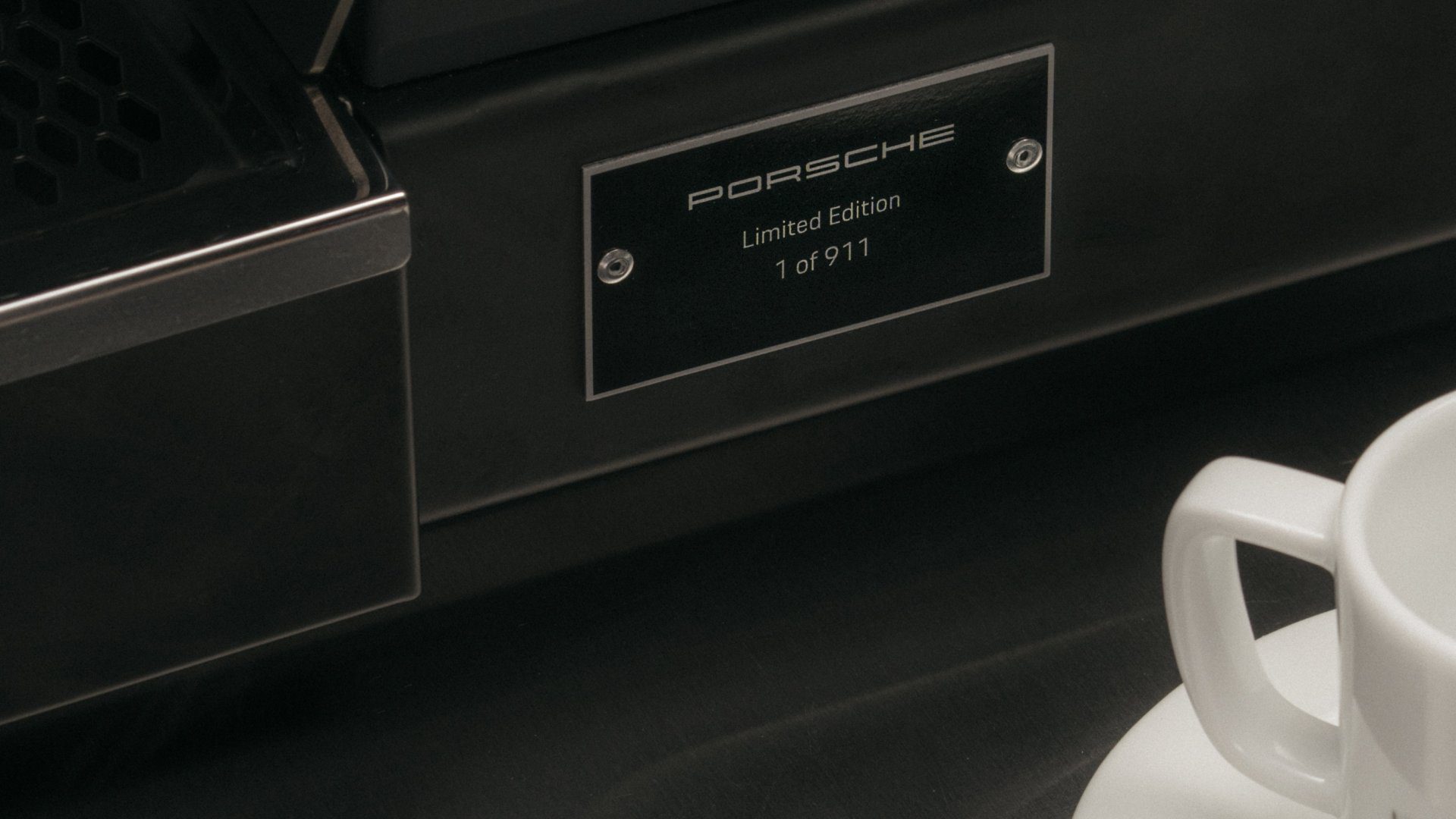 A numbered plaque on the side of the La Marzocco Linea Micra x Porsche 911.