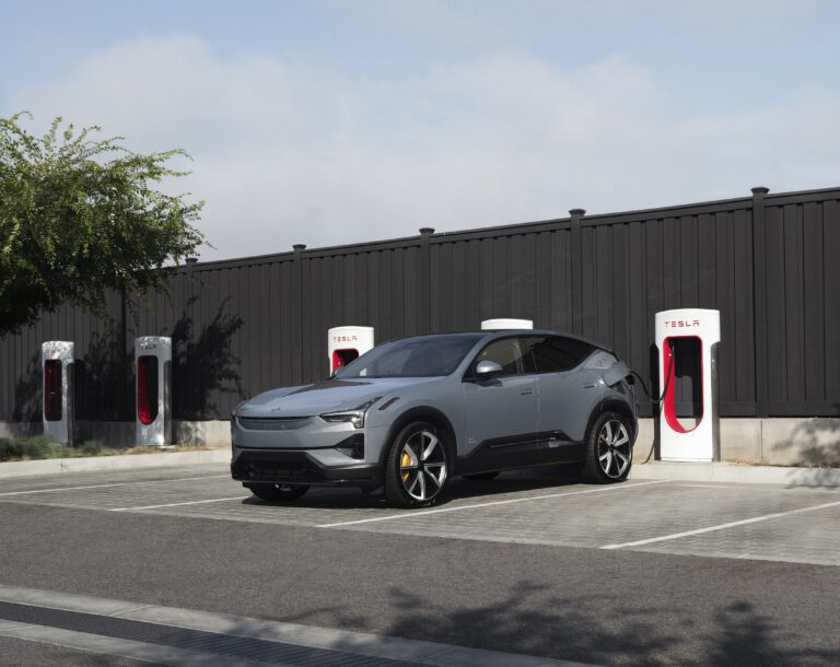 A Polestar car in front Tesla Superchargers