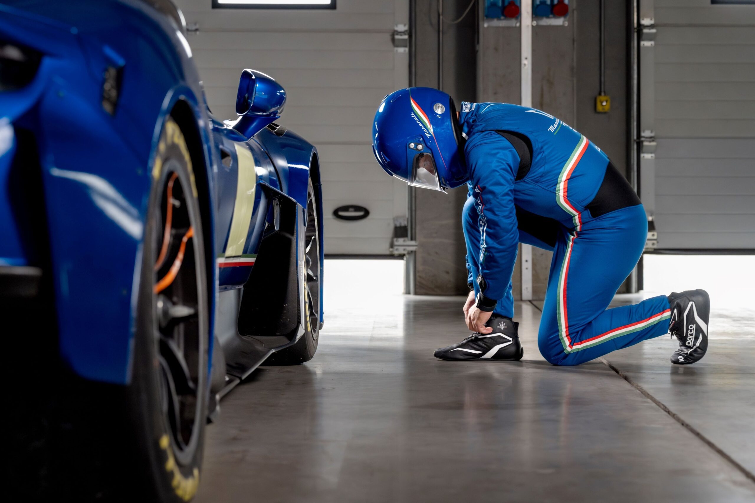 A driver suited in the Maserati and Sparco collaboration racing suit, gloves, helmet and shoes.