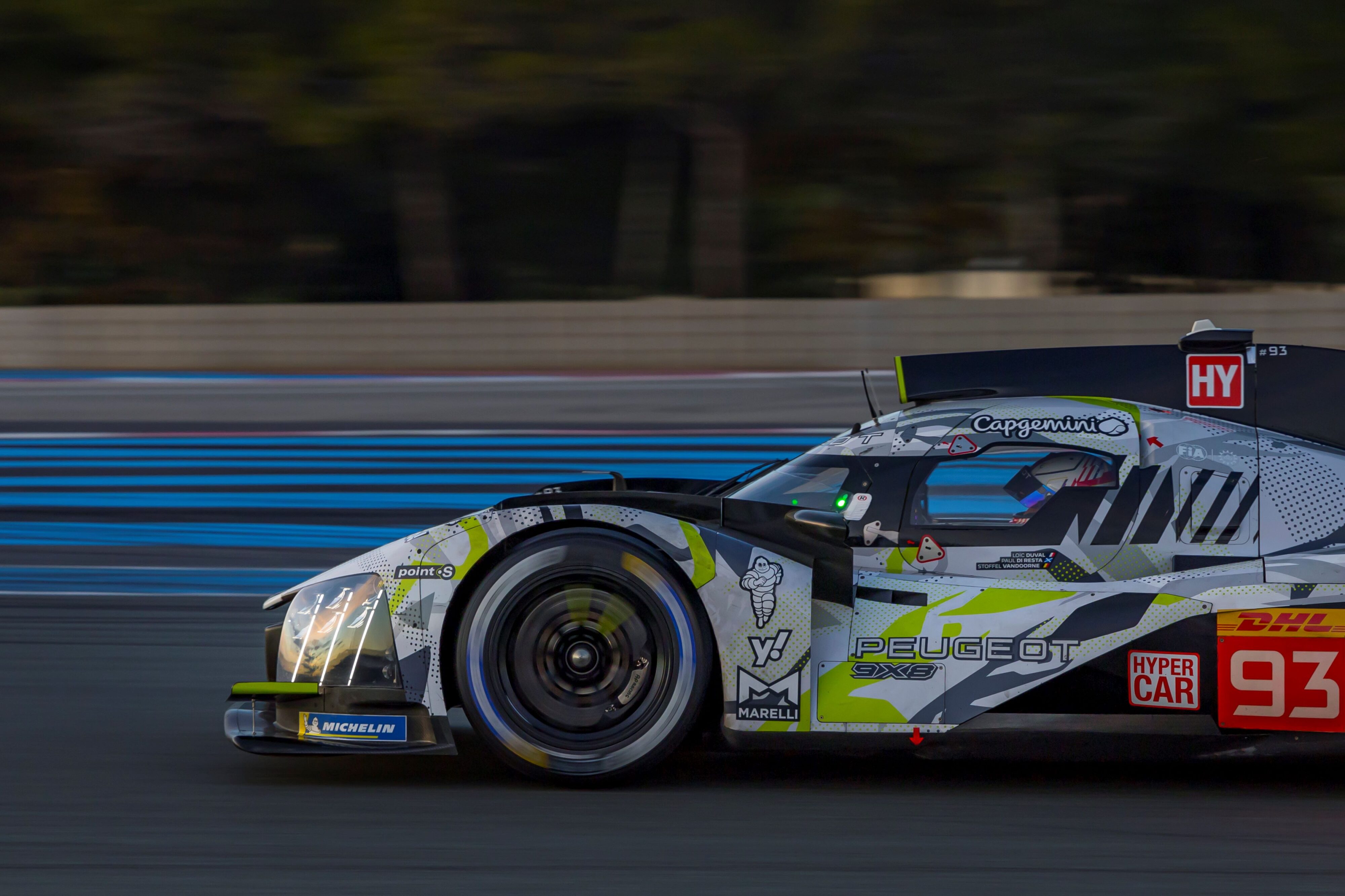 A side view photo of the Peugeot 9X8 hypercar undergoing testing with a Point S logo on the side.