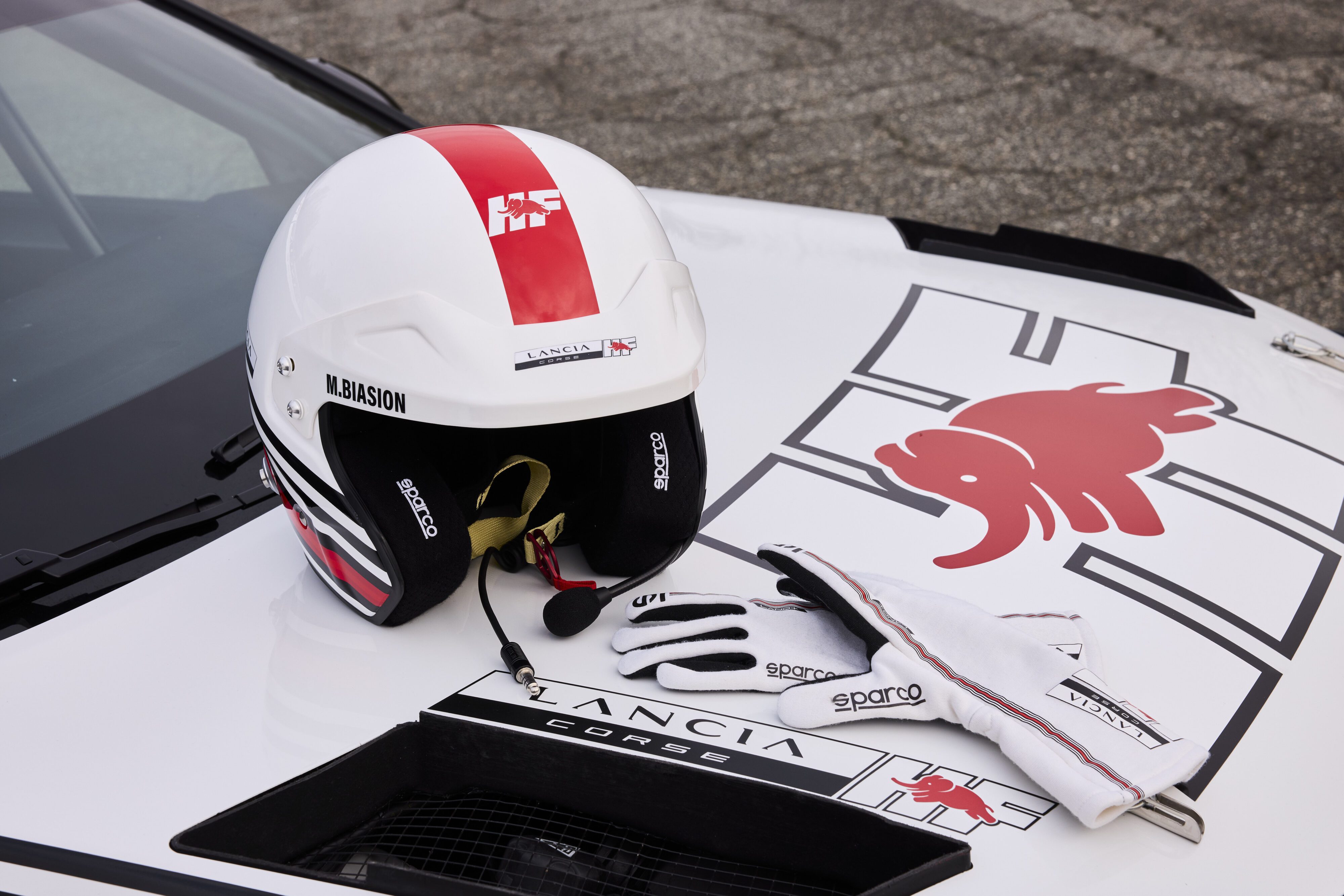 Sparco Lancia HF motorsport equipment on a Lancia Ypsilon Rally 4 in white.