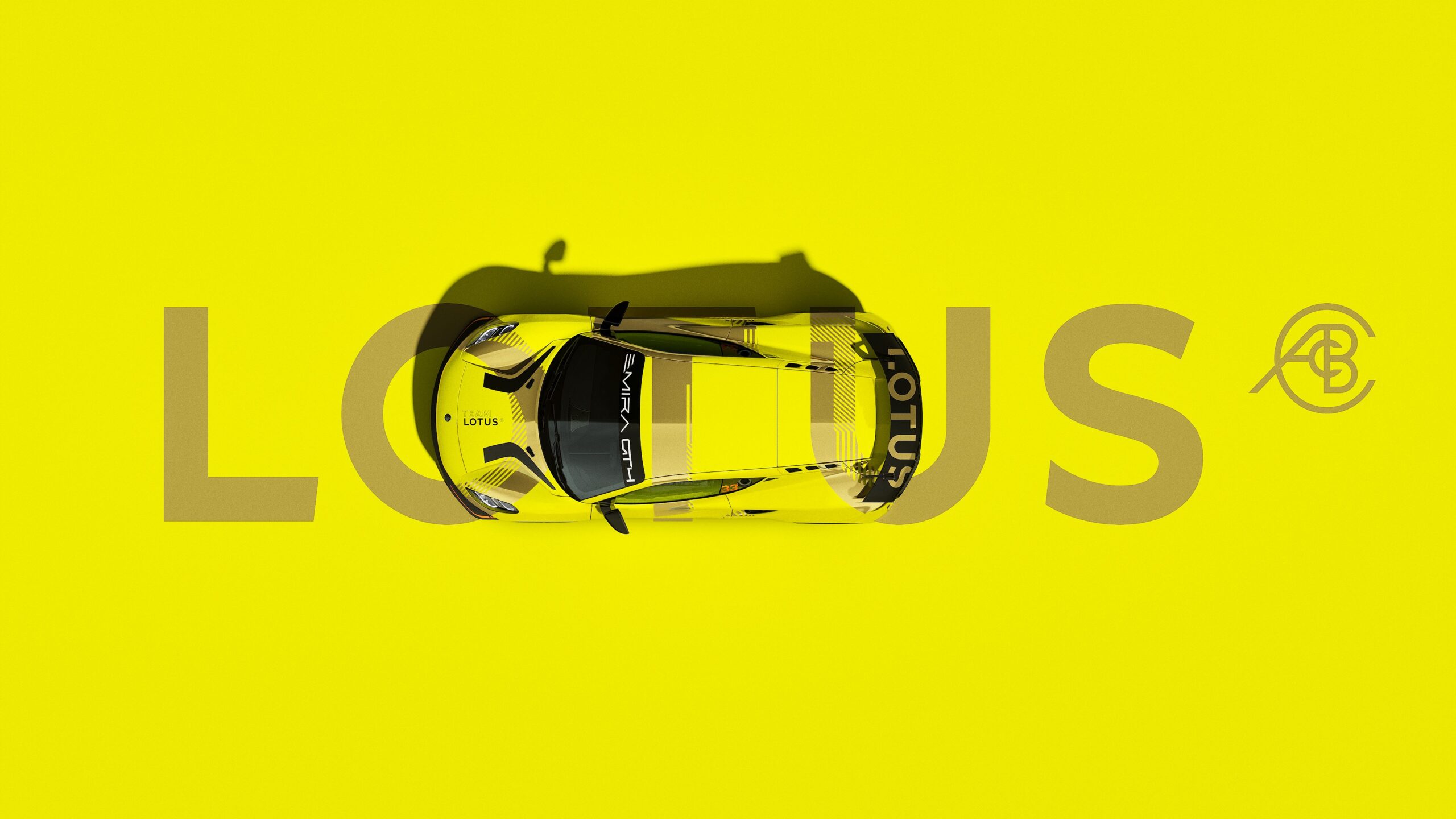 A promotional photo showing a yellow Lotus Emira GT4 with the word Lotus in the background.