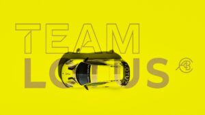 A promotional photo showing a yellow Lotus Emira GT4 with the words Team Lotus in the background.