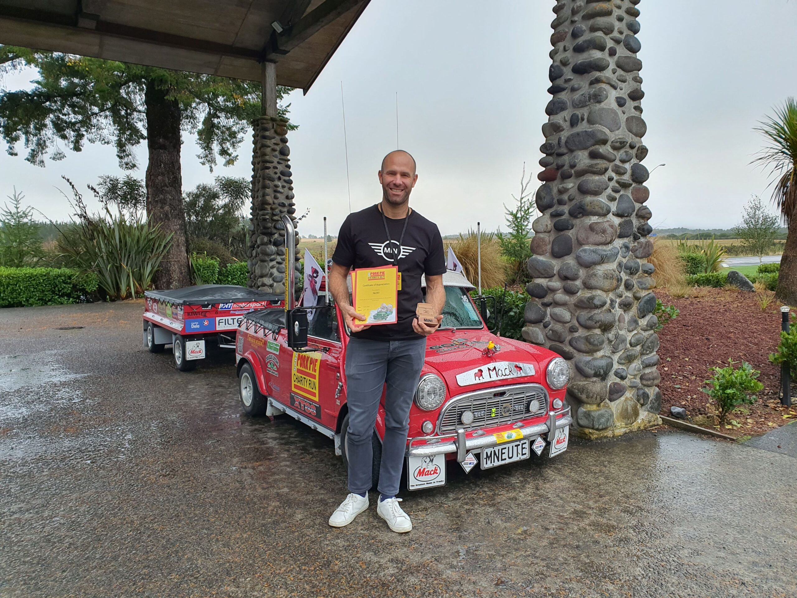 Alex Brockhoff poses in front of Mini Mack with his award on the 2025 Pork Pie Charity Run.