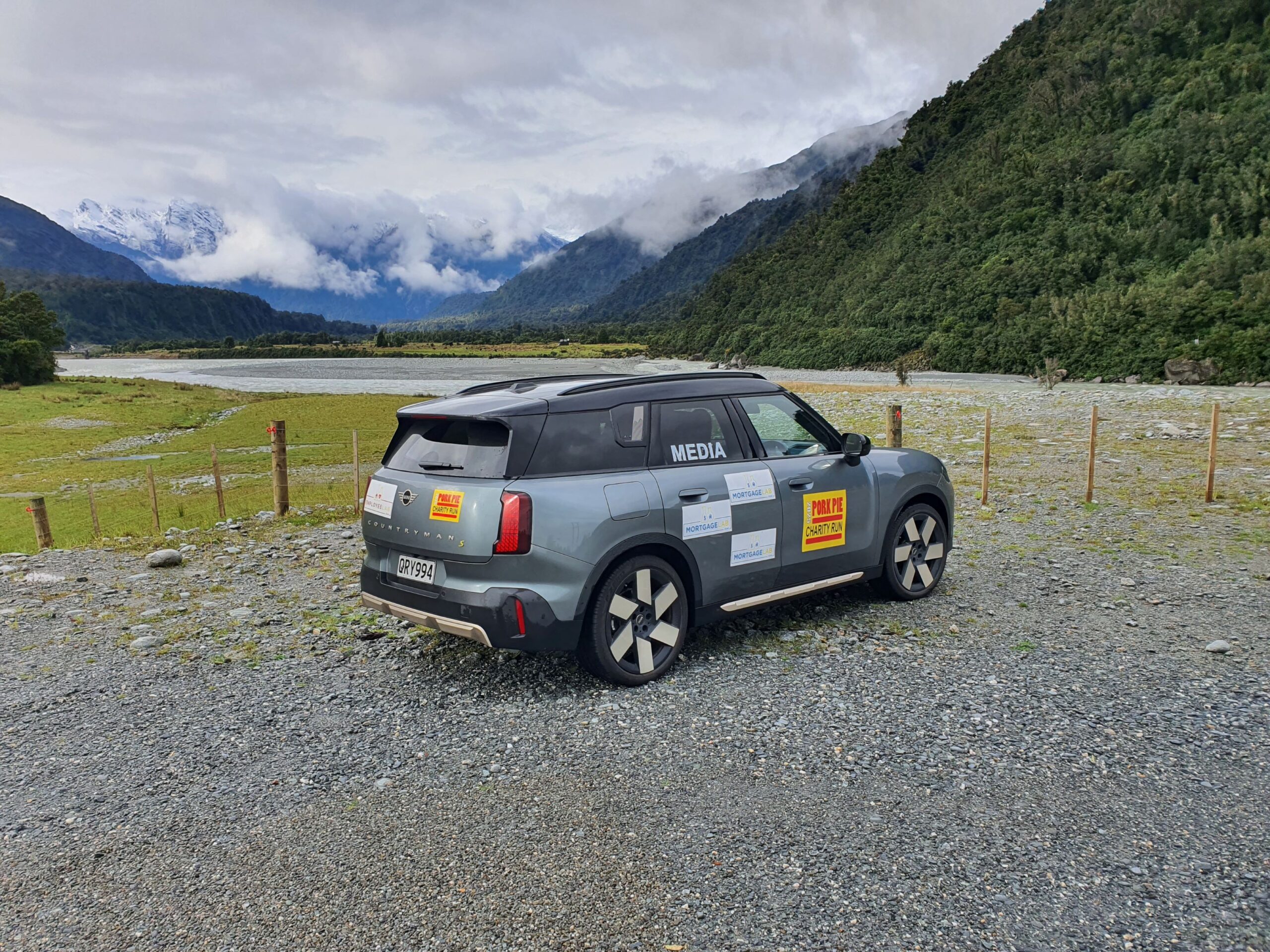 Rear three quarters view of a 2025 Mini Countryman SE All4 with Mortgage Lab branding and the Southern Alps in the background on the 2025 Pork Pie Charity Run.