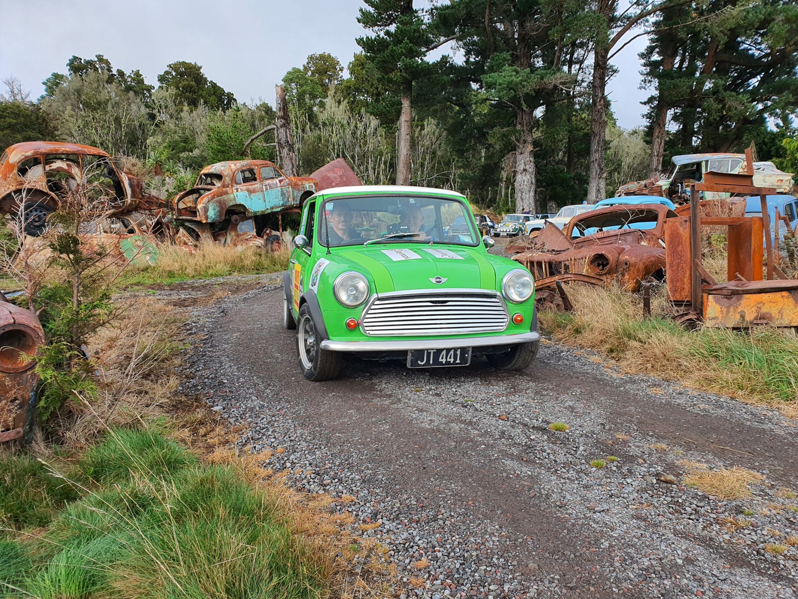 A classic Mini driving through Smash Palace in Horopito as part of the 2025 Pork Pie Charity Run.
