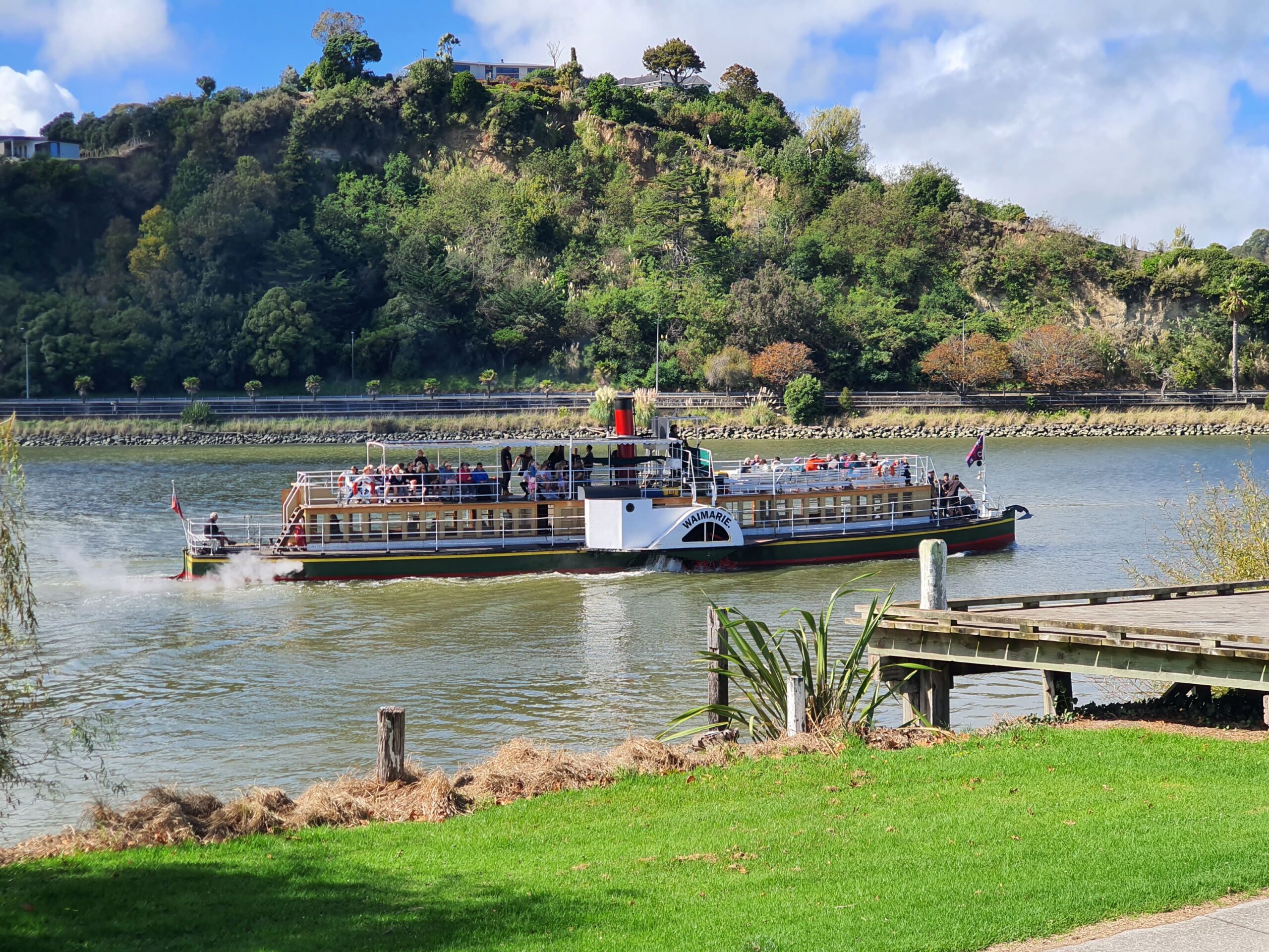 A steamship sailing alongside the town of Whanganui in New Zealand's North Island.