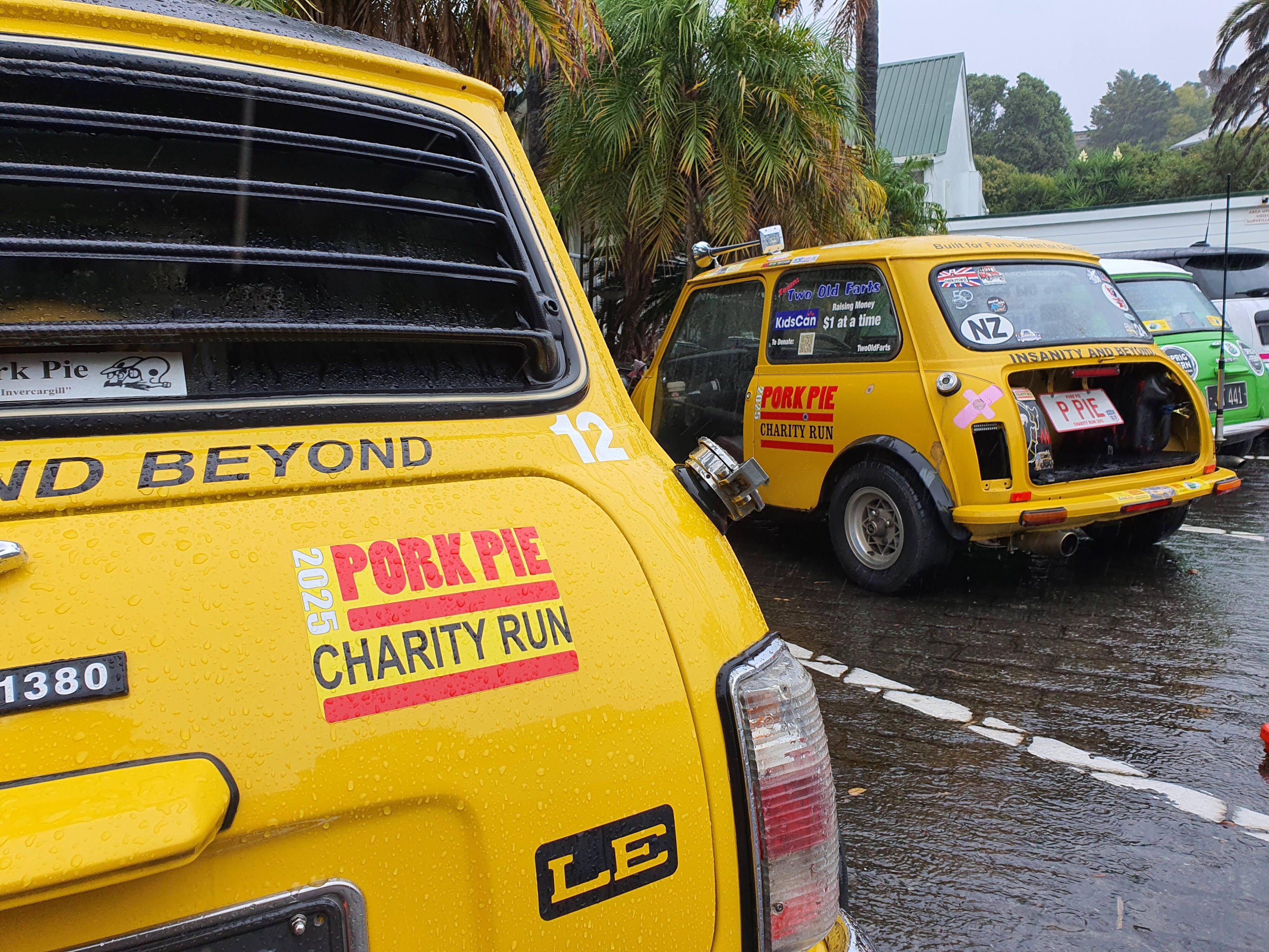 View of two classic yellow Minis with the 2025 Pork Pie Charity run sticker on.