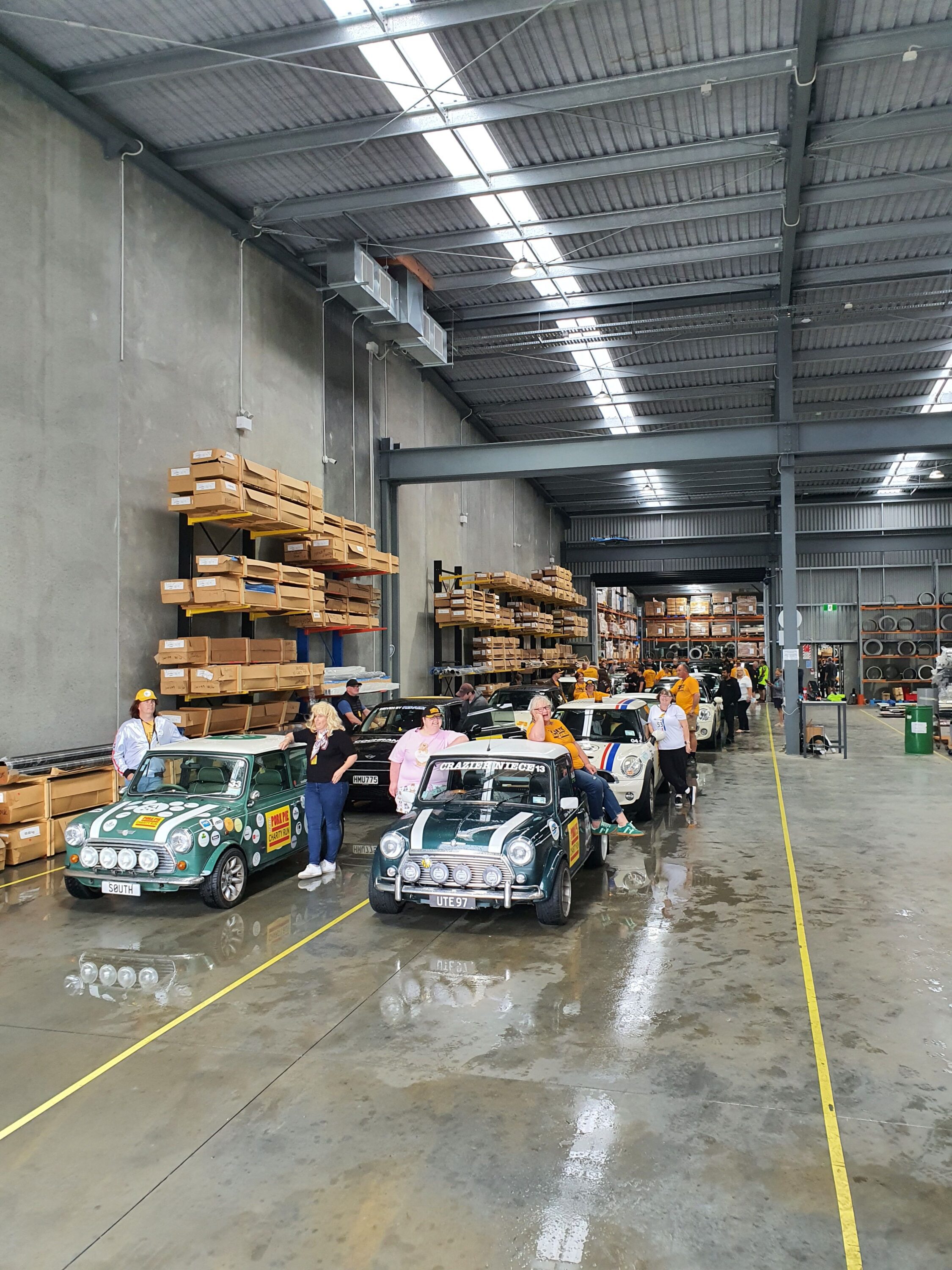 A photo of a group of Minis driving through the factory of Roofing Industries Waikato in Hamilton as part of the 2025 Pork Pie Charity Run.