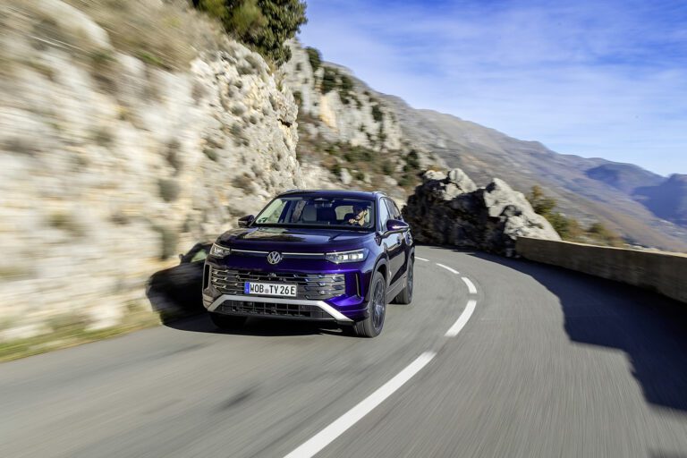 A photo of a blue Volkswagen Tayron SUV in motion.