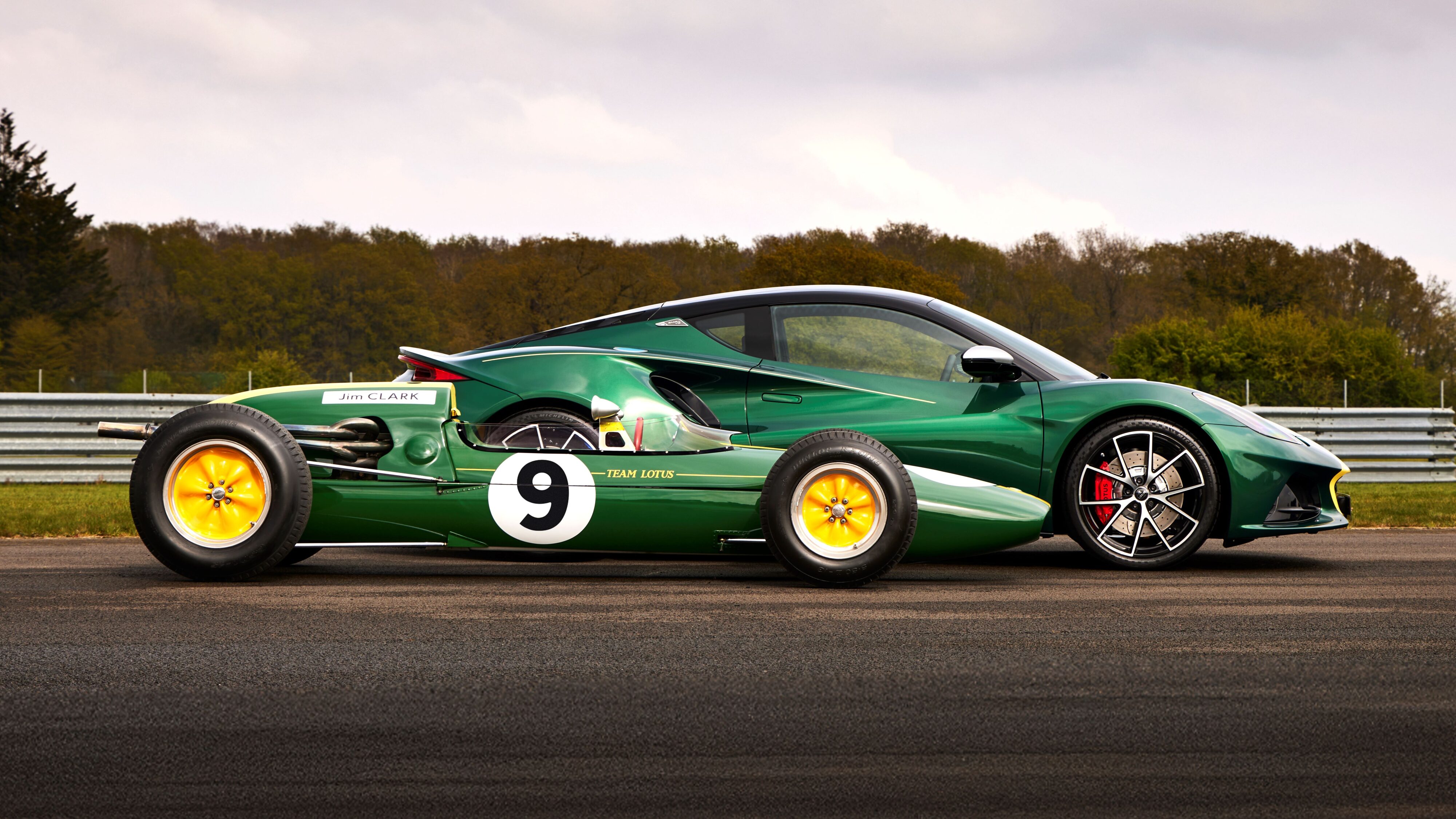 Side on view of a Lotus F1 car driven by Jim Clark and a Lotus Emira Clark Edition.