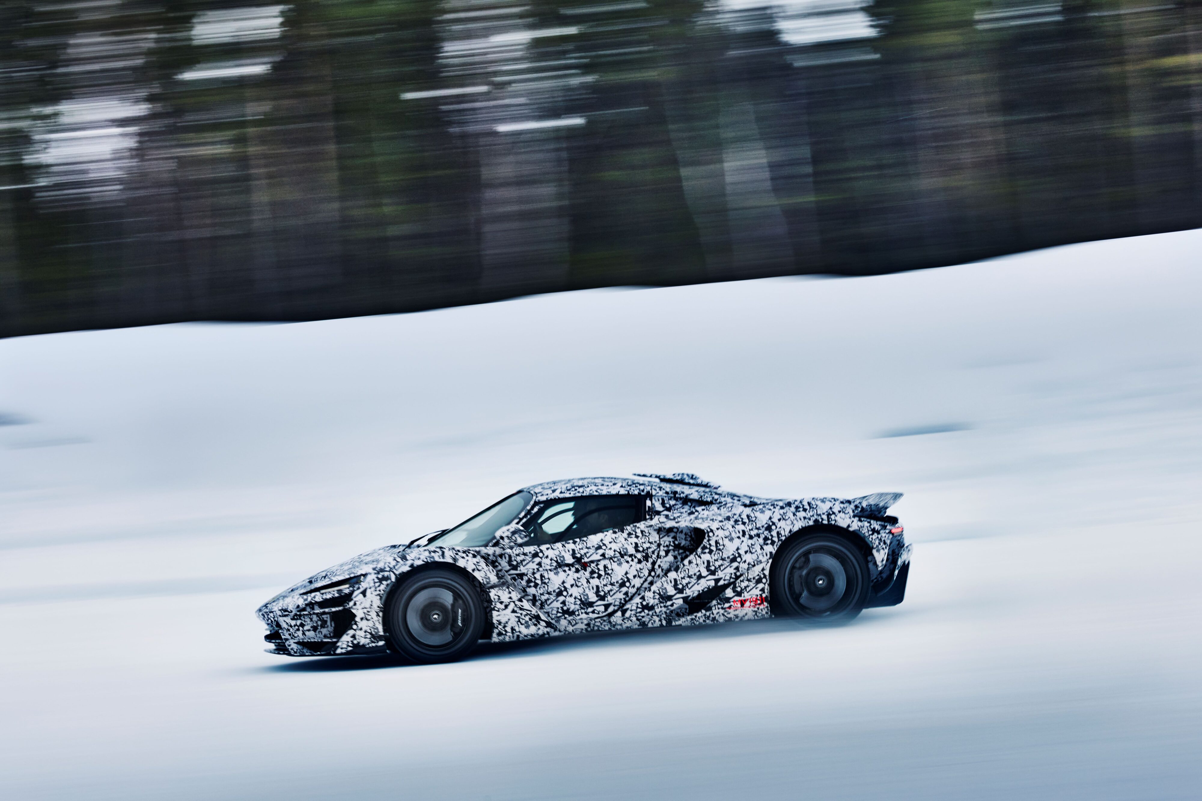 Side on view of a camouflaged McLaren W1 in cold weather testing in the Arctic Circle.