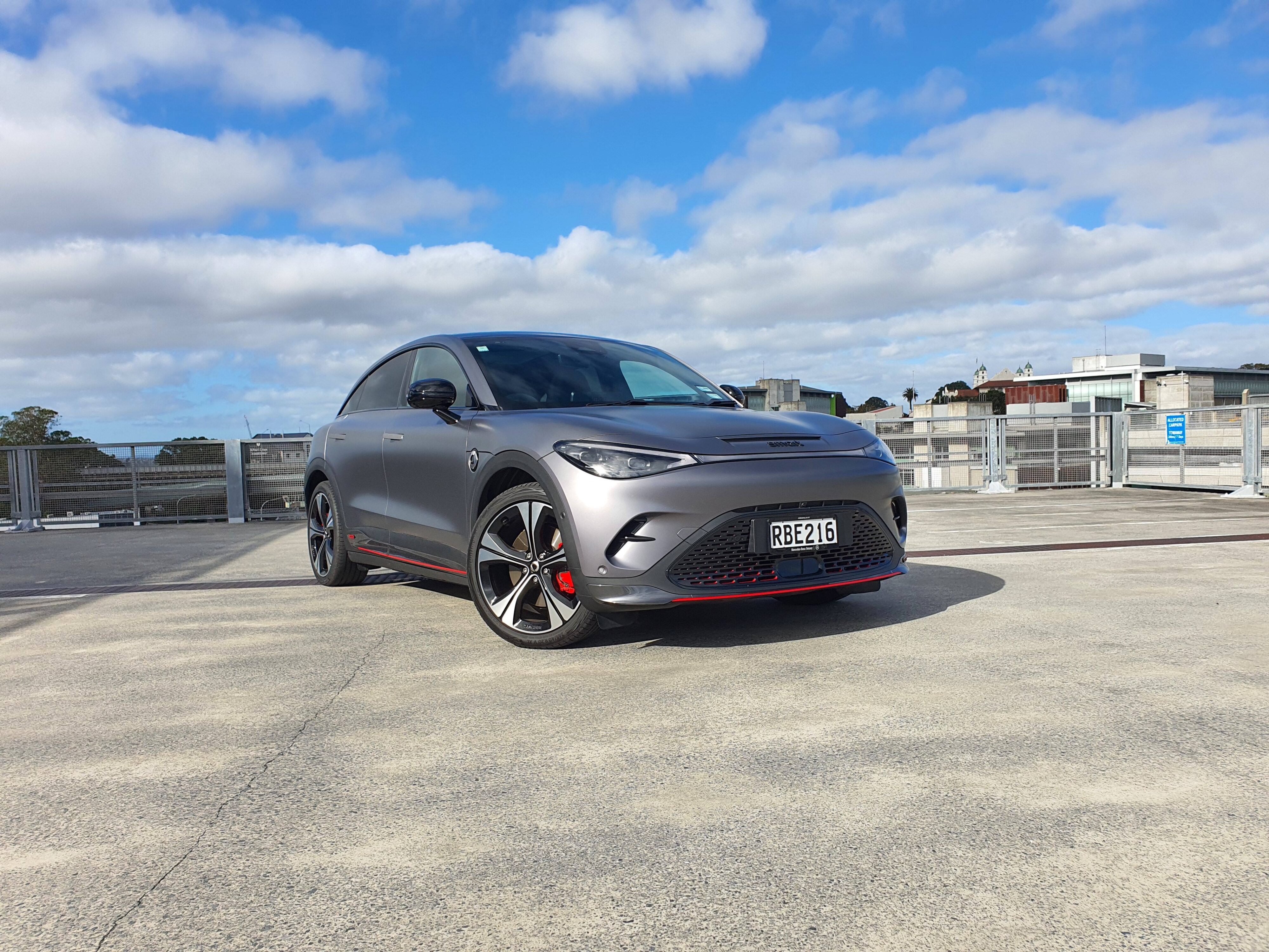 Front three quarters view of a matte grey 2025 smart #3 Brabus photographed atop a parking building in Auckland.