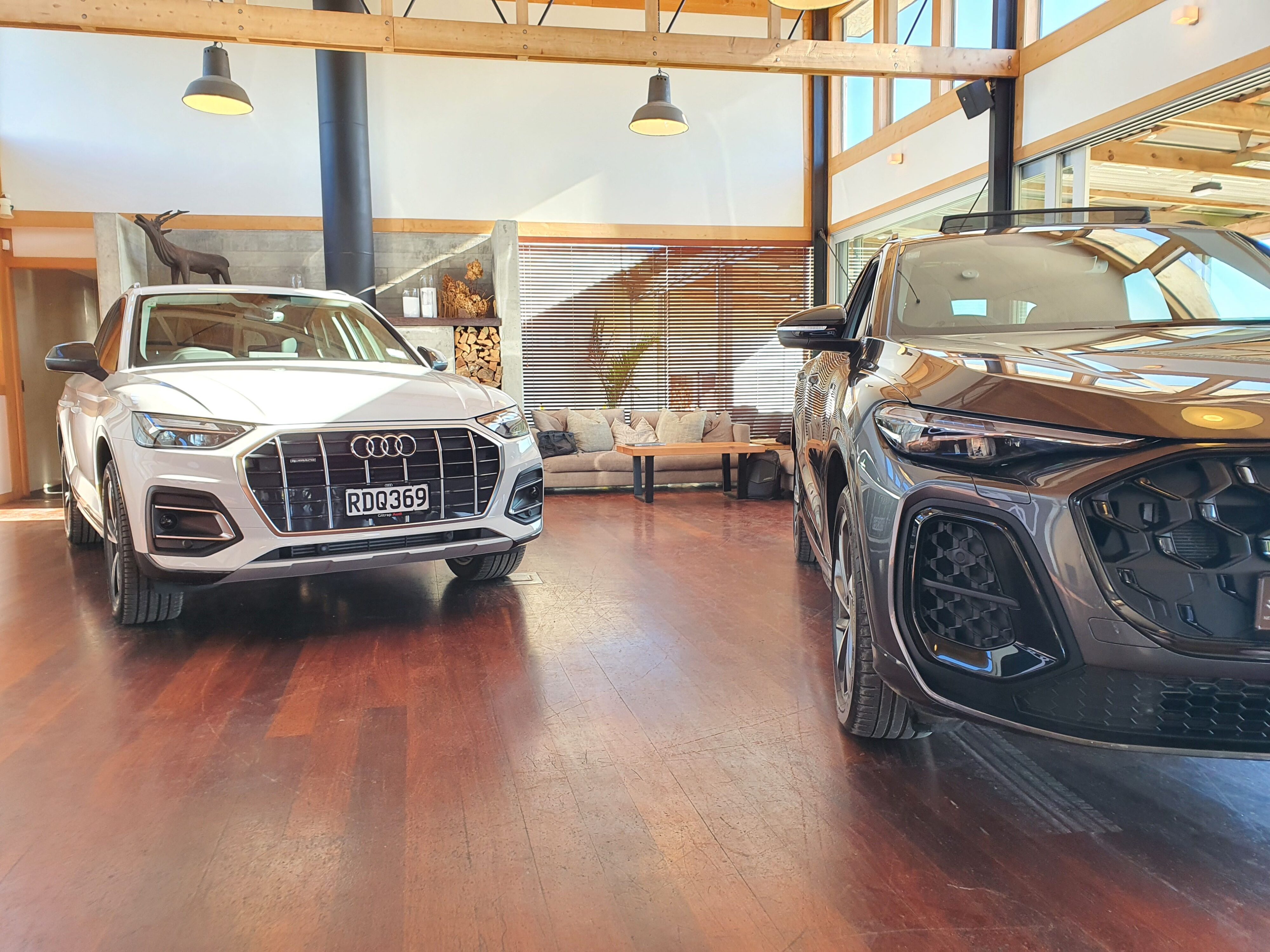 A photo of a second generation Audi Q5 (left), pictured with a third generation car (right).