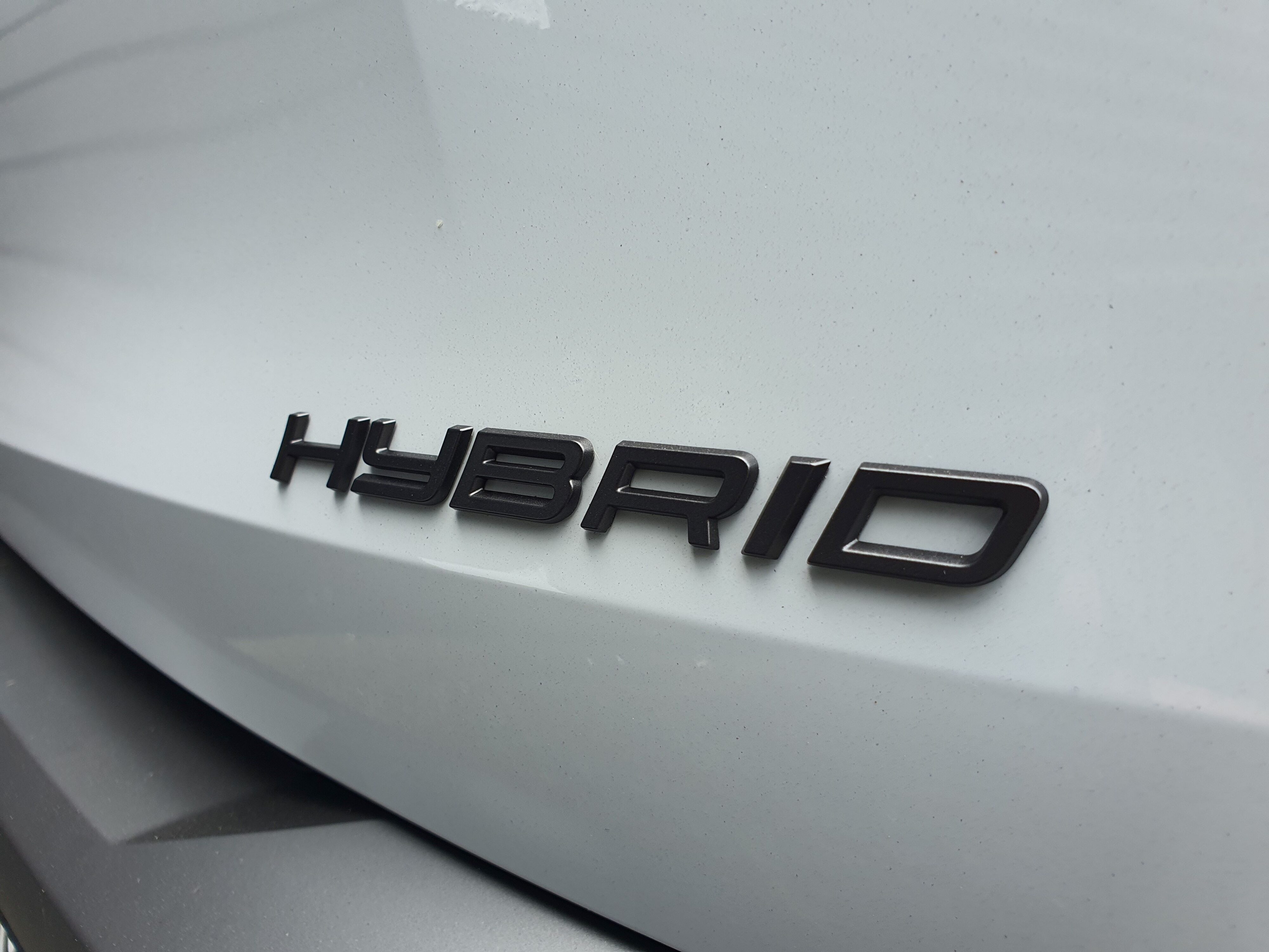 'Hybrid' badging on the rear of a 2025 Peugeot 5008 Hybrid in Okenite White and Diamond Black.