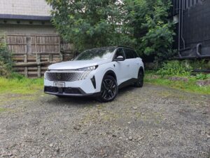 Front three quarters view of a 2025 Peugeot 5008 Hybrid in white and black.