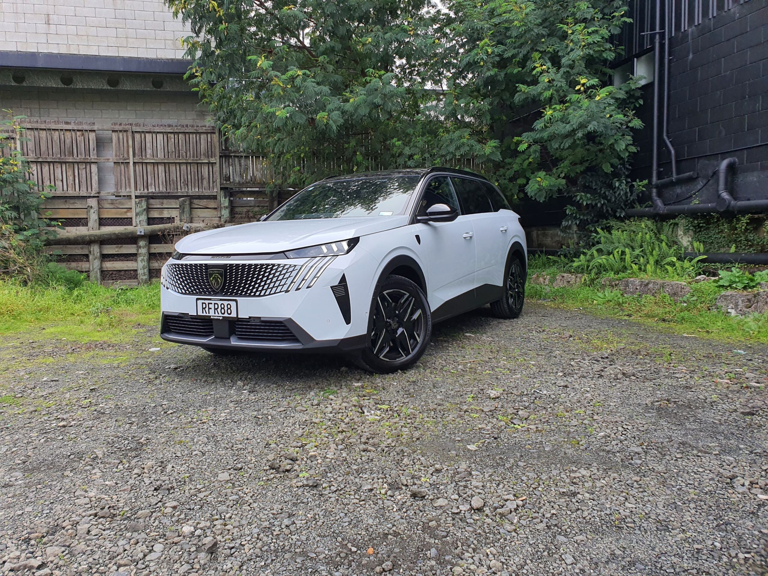 Front three quarters view of a 2025 Peugeot 5008 Hybrid in white and black.
