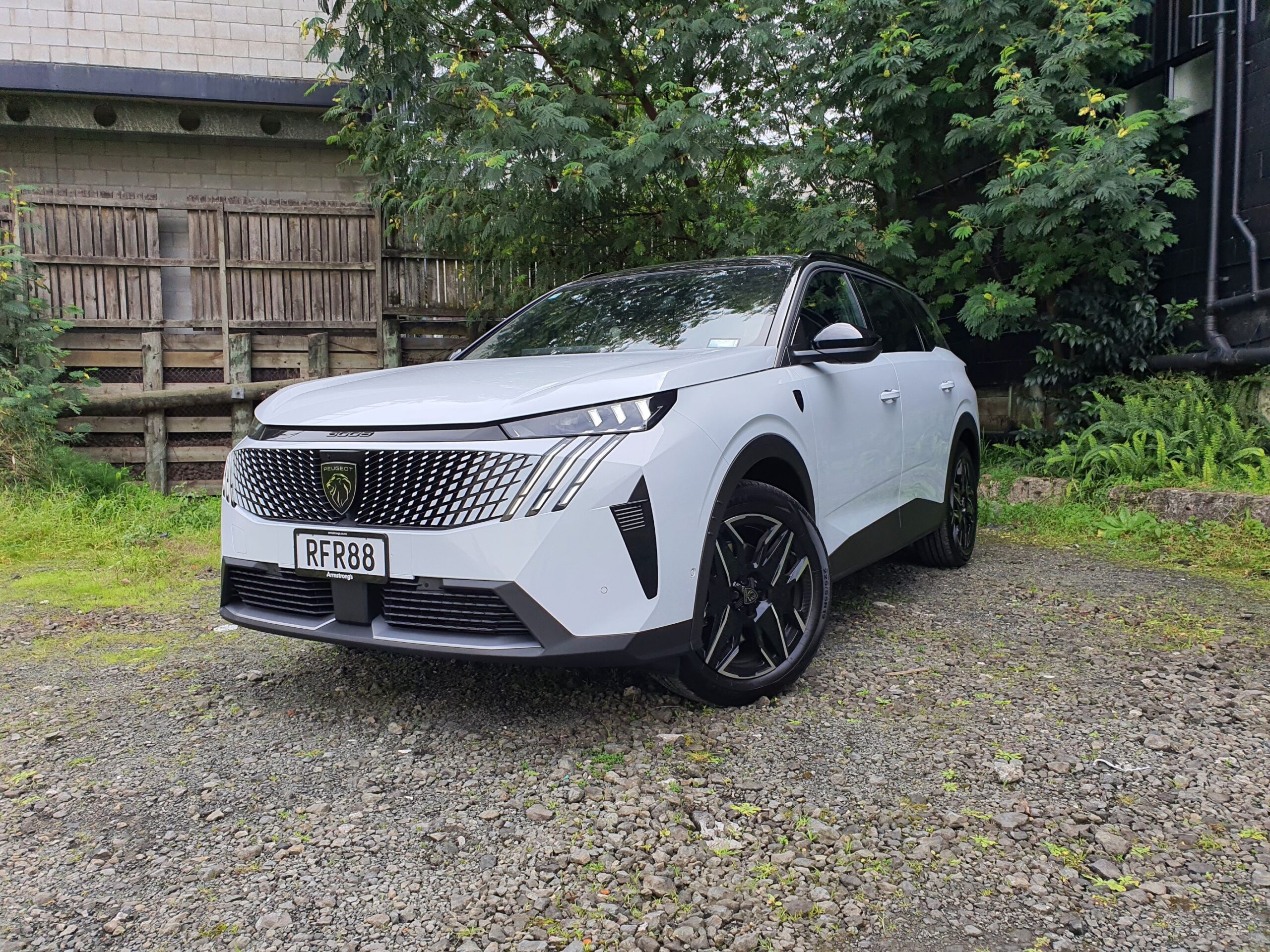 Front three quarters view of a 2025 Peugeot 5008 Hybrid in white and black.