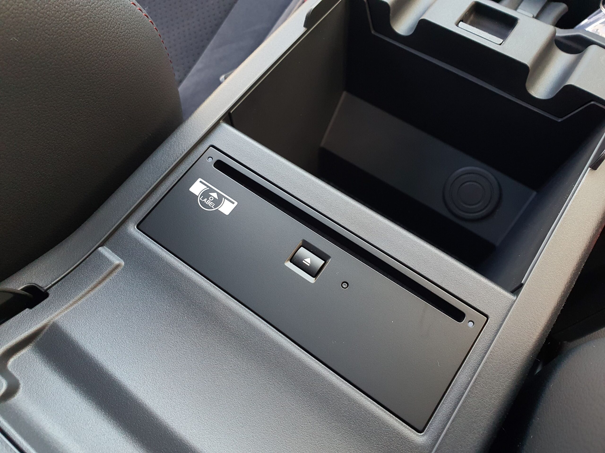 A CD player hidden under the central armrest in a 2025 Subaru WRX GT tS Wagon.